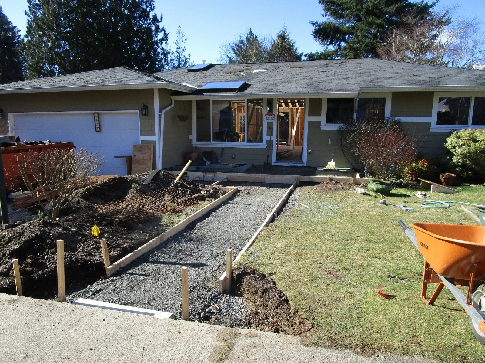 Meanwhile out front, we are adding an alcove entry and covered entry stoop. That framing has not started yet. First, pour the concrete.