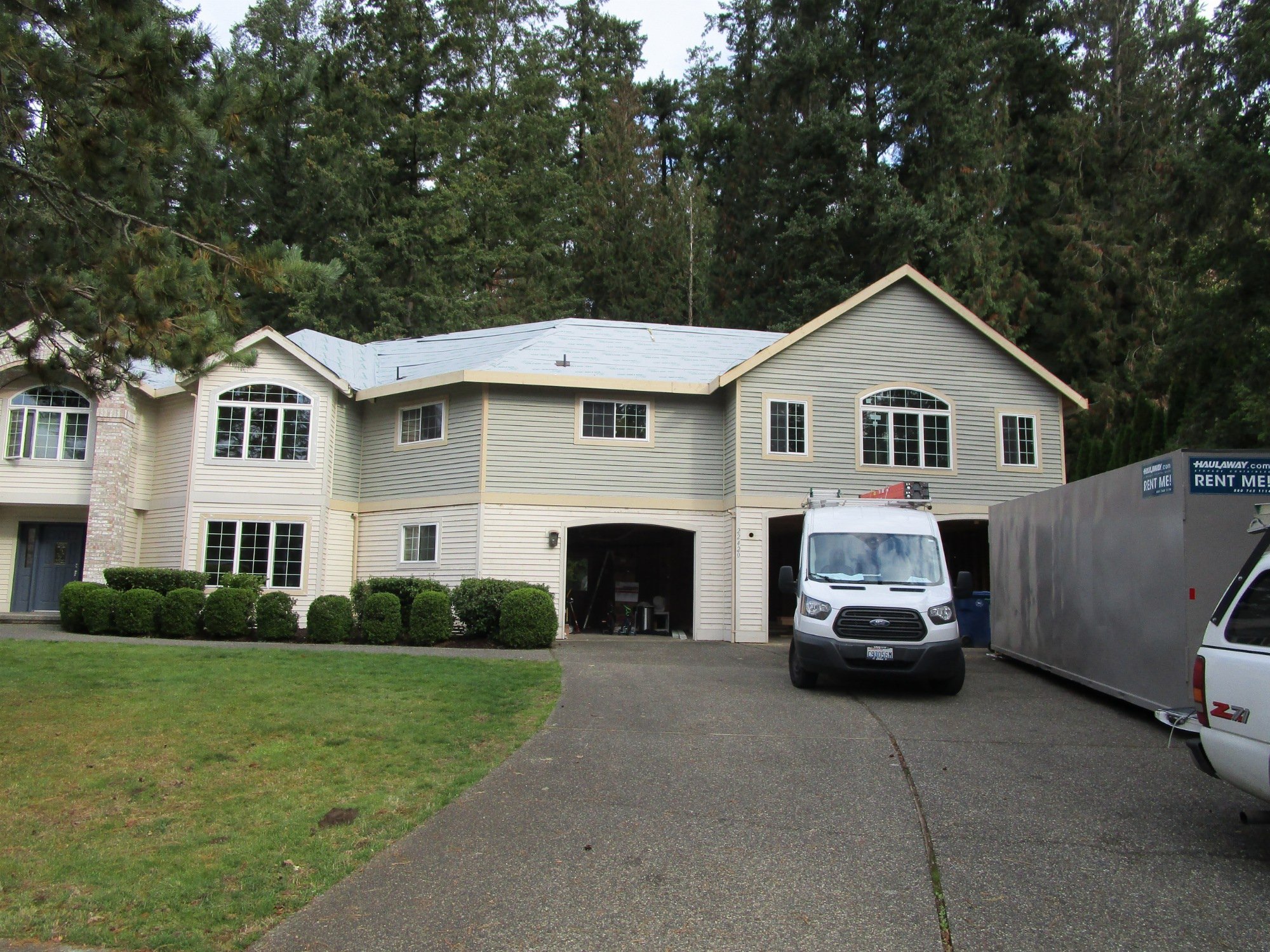 Exterior siding being hung and roofing underlayment is in place.