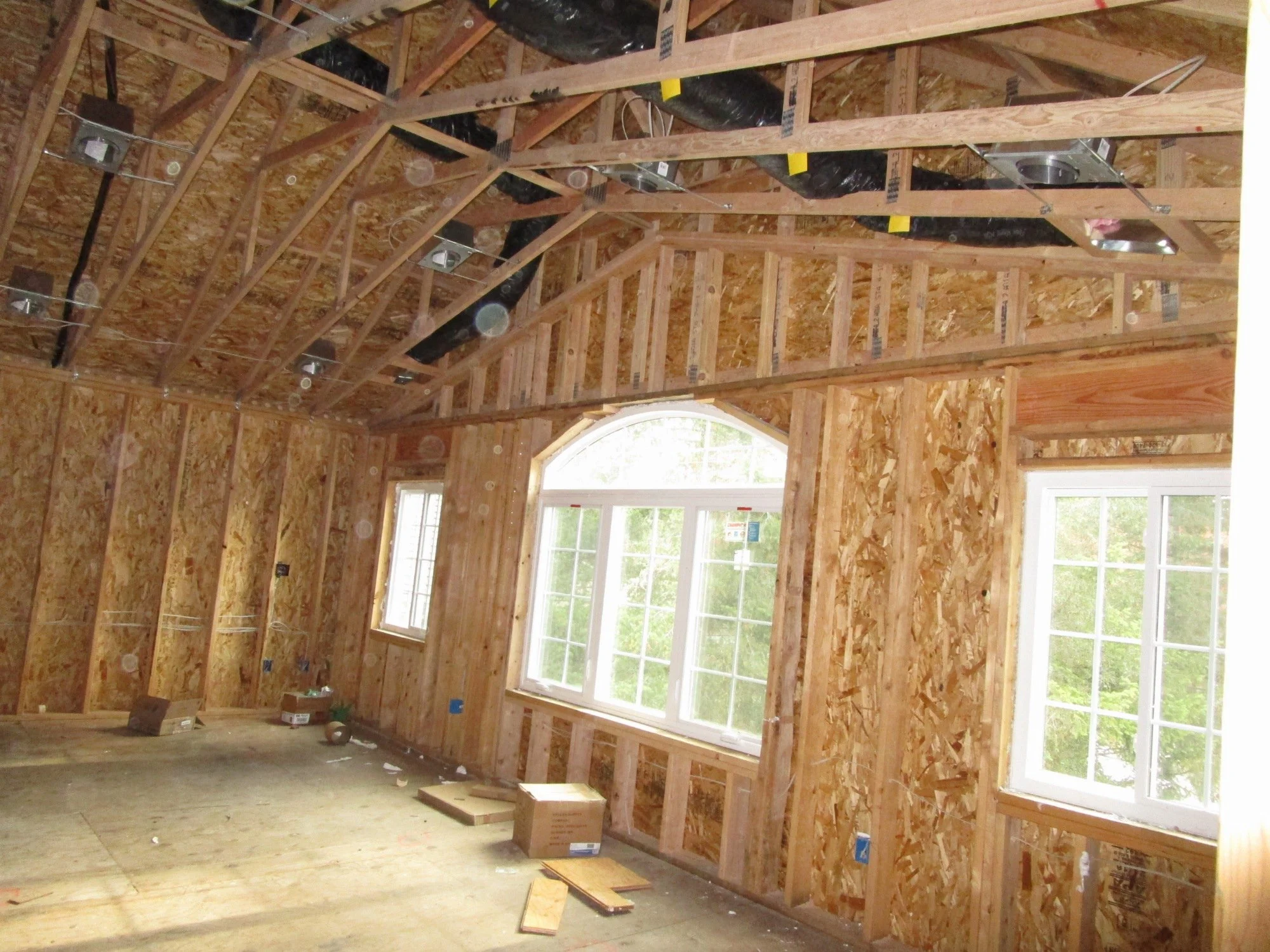 Ductwork going in for heating. Note the scissor trusses to create a vaulted ceiling.