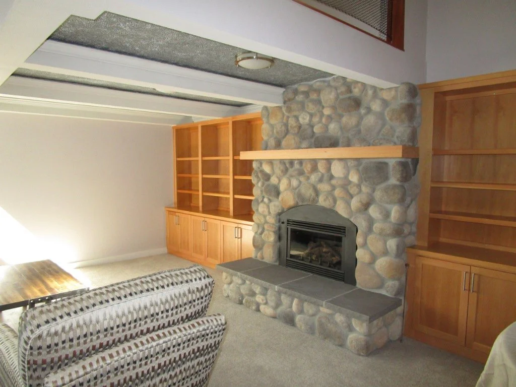 Some rustic stone veneer at the lower level fireplace.