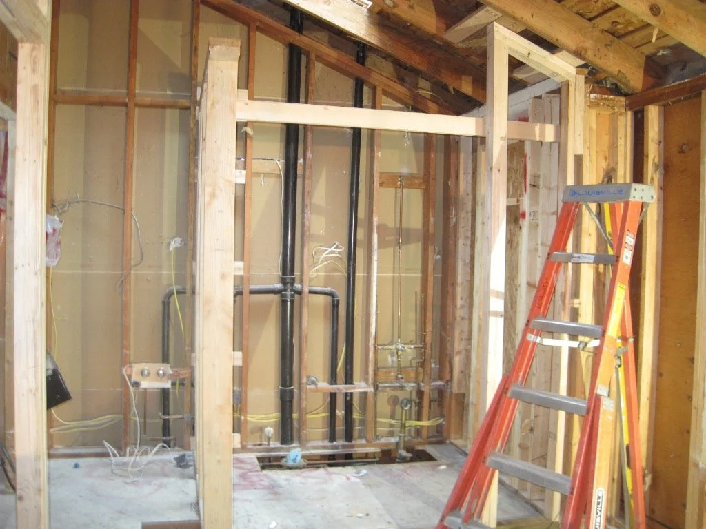 View of the gutted small bath, which will turn into the new expanded Master Bath. Shot taken from the soaking tub platform, all of that plumbing and venting is existing from the old bathroom. Most of 