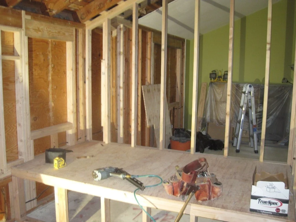 View of the soaking tub platform. A window is being framed in to the left over the platform. Green wall beyond will be part of the Master Bedroom. This whole area was 2 smaller bedrooms and a shared b