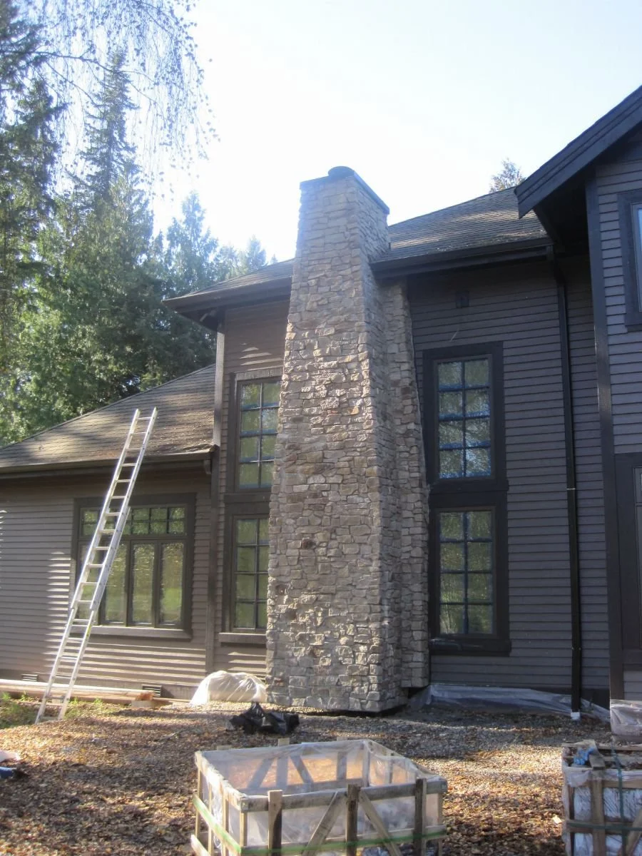 Outside, the back side of the house receives finishes.