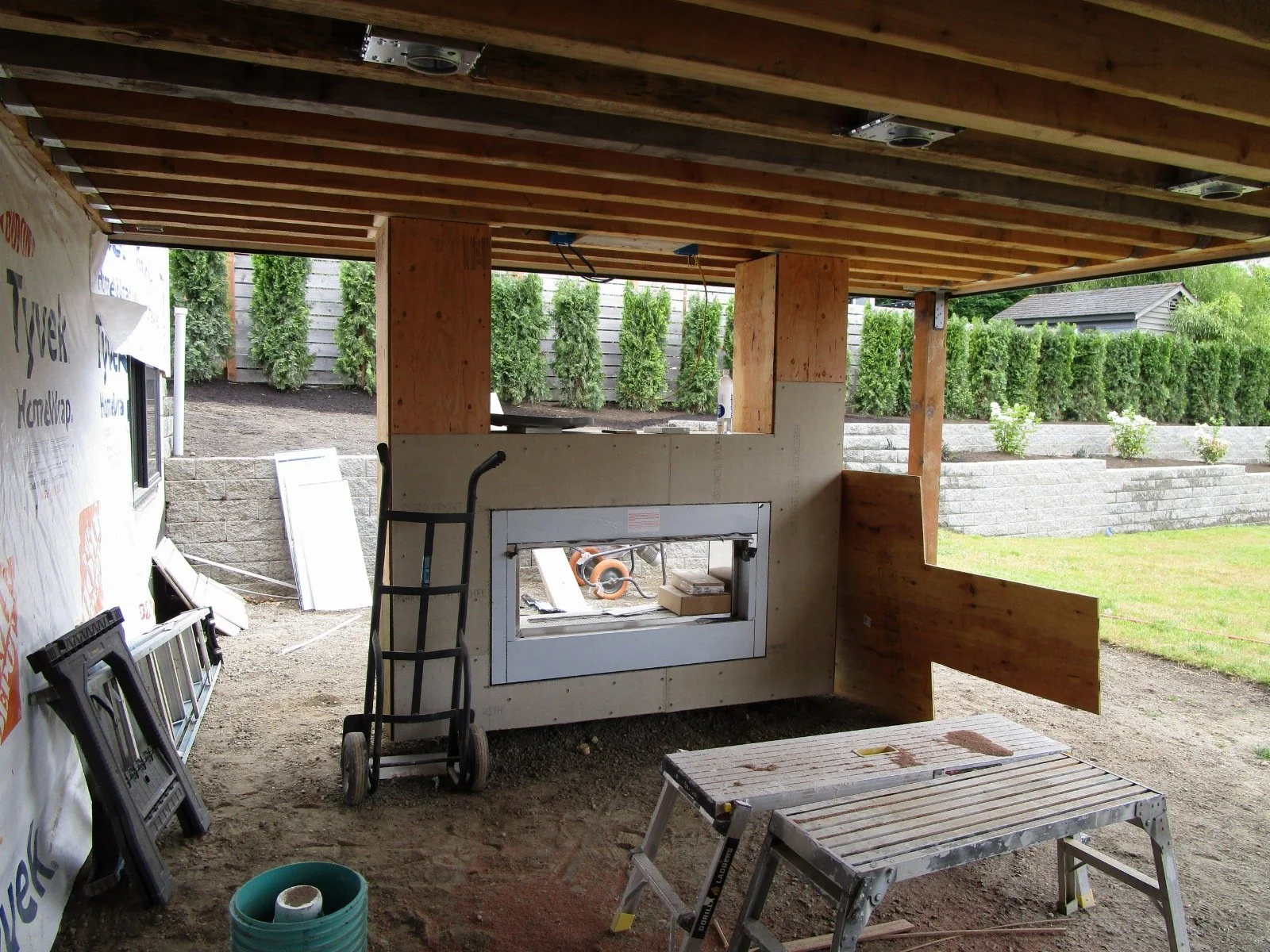 Outside, a 2-sided fireplace is going in. One side, under the deck. The other side, open air.