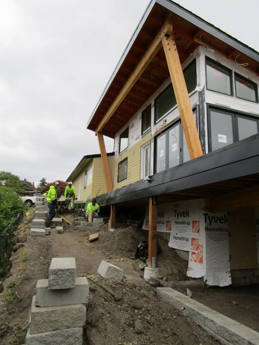 On the west side, the landscape crew are setting keystone blocks and starting to set final grades.