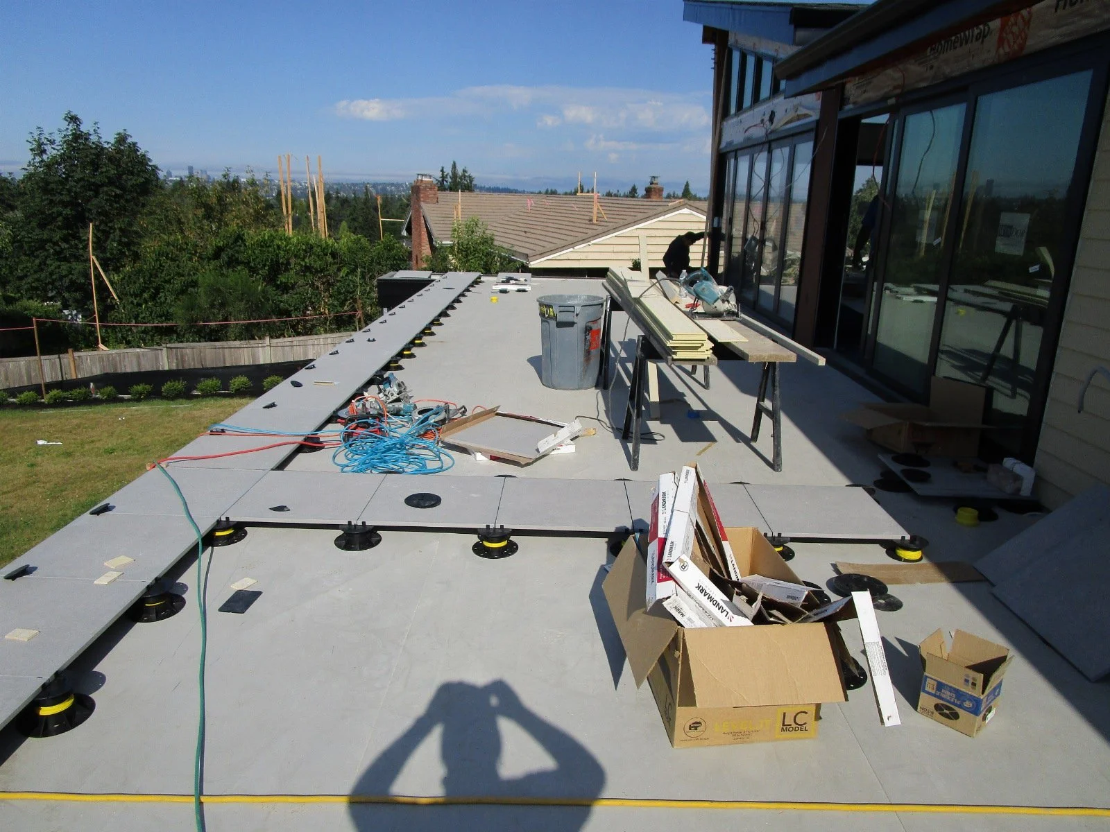 Pavers being installed. The substrate is waterproof and sloped to the left edge to drain rain water.