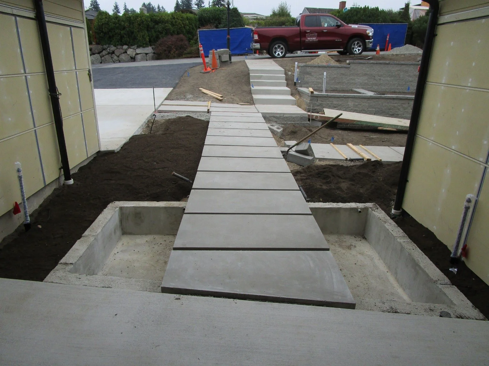 Standing at the covered entry. Water features flanking the walkway are closer to getting water.