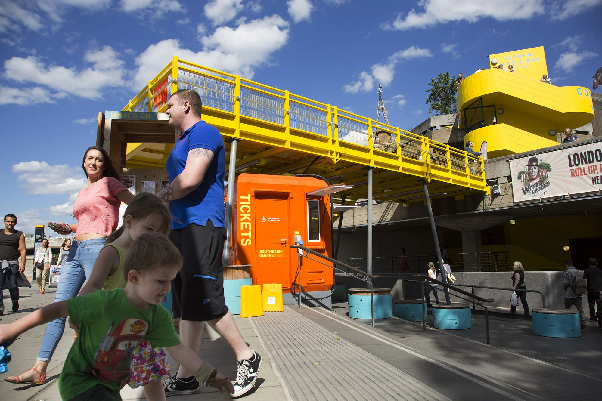Kids playing near the yellow gantry walkway which joins a terrace to the main walkway on the South Bank.