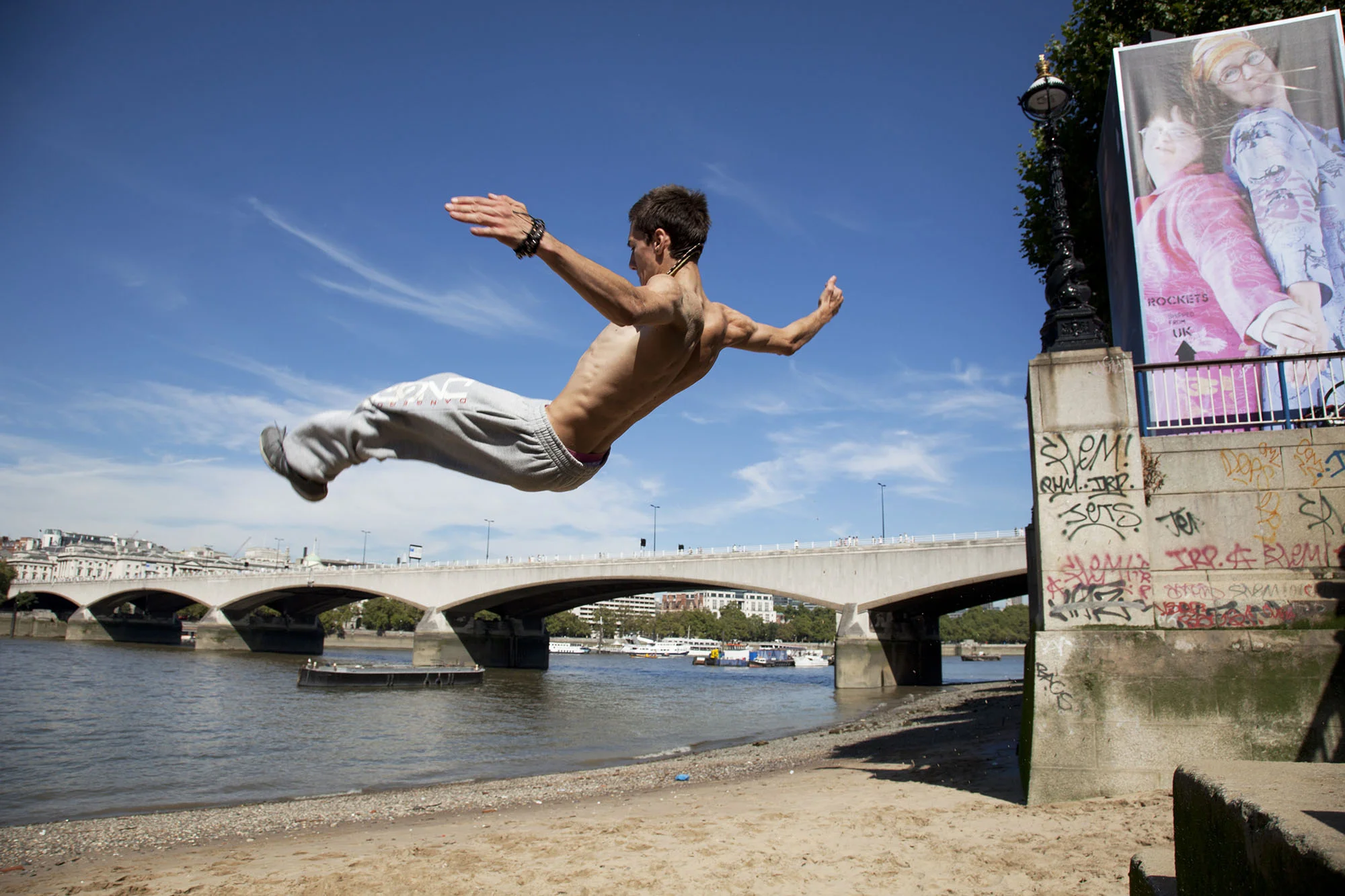 A parkour runner somersaults off the steps down to the beach on the South Bank.