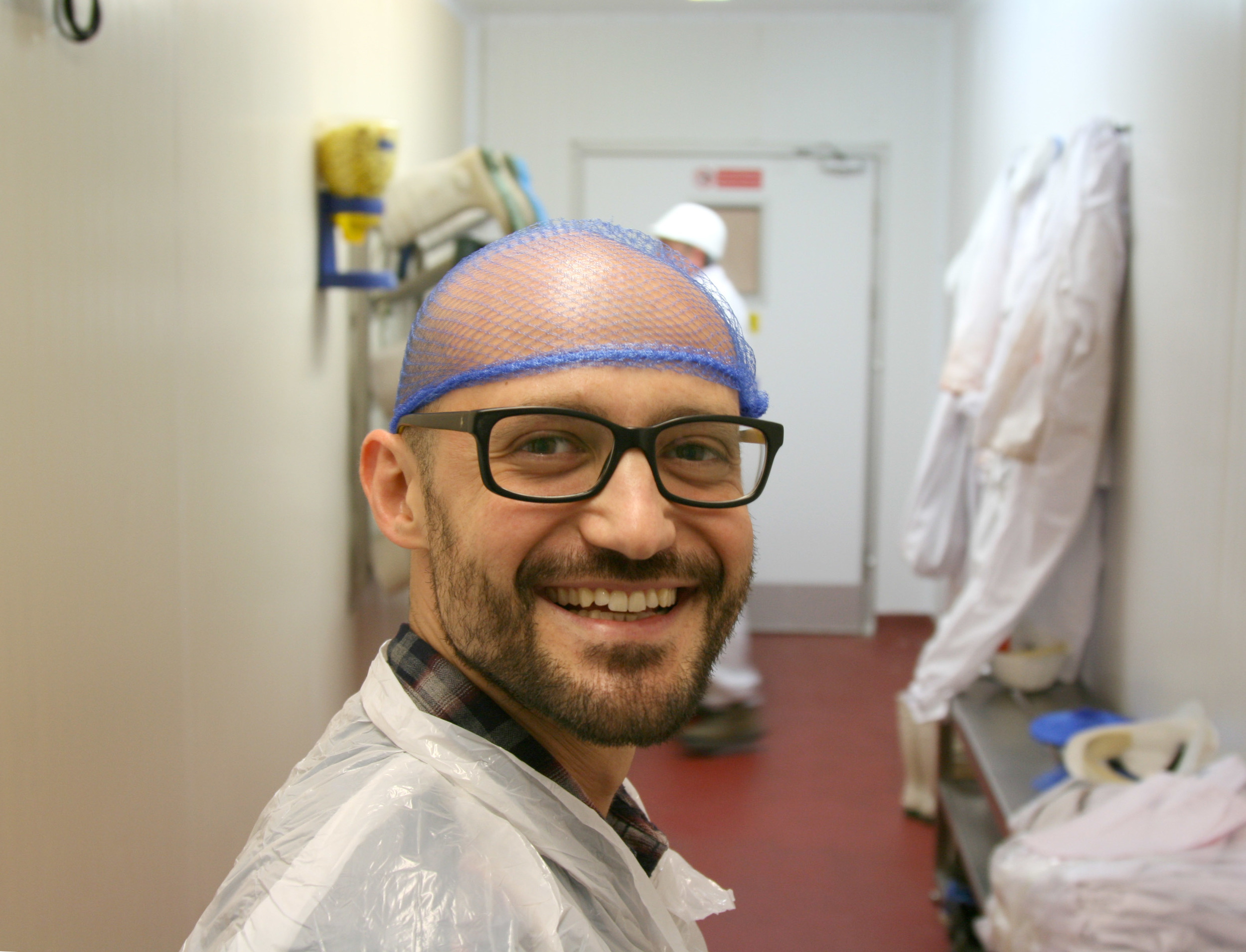 Alessandro, obviously pleased by his plastic coat & 'hairnet', entering the butchery.
