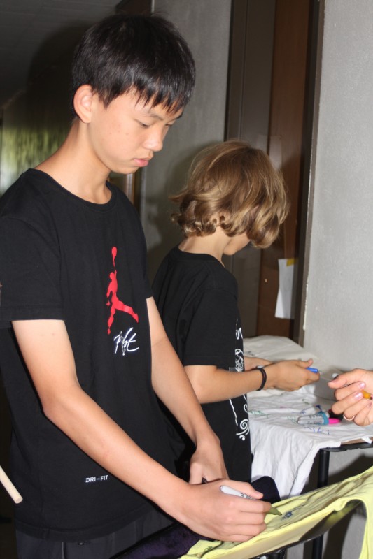 Students signing each other's camp t-shirts on the last day of one of our Oregon camps