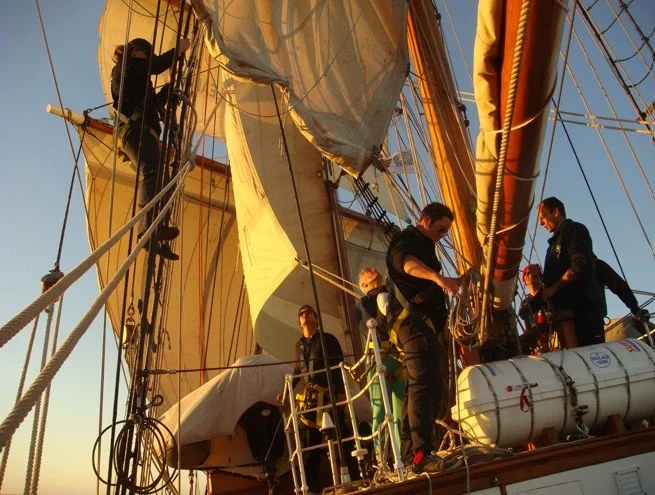 crew on deckhouse roof with sails.jpg
