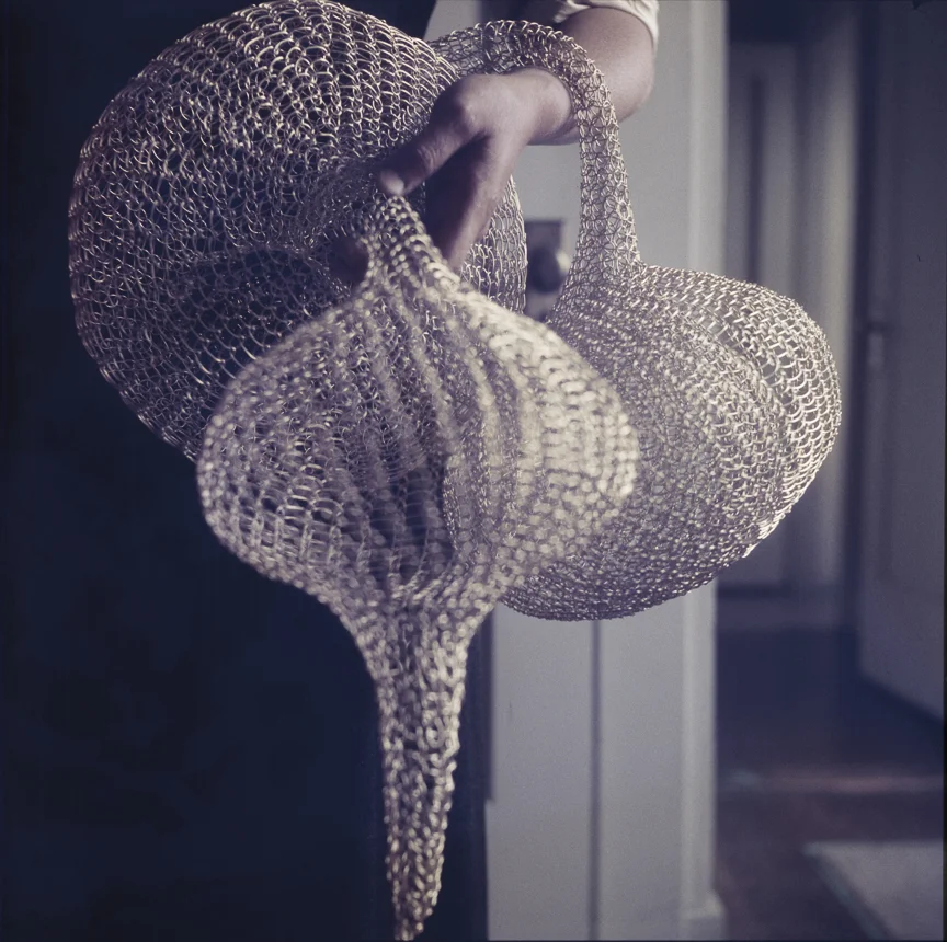 Ruth Asawa holding her tied wire sculpture, nd