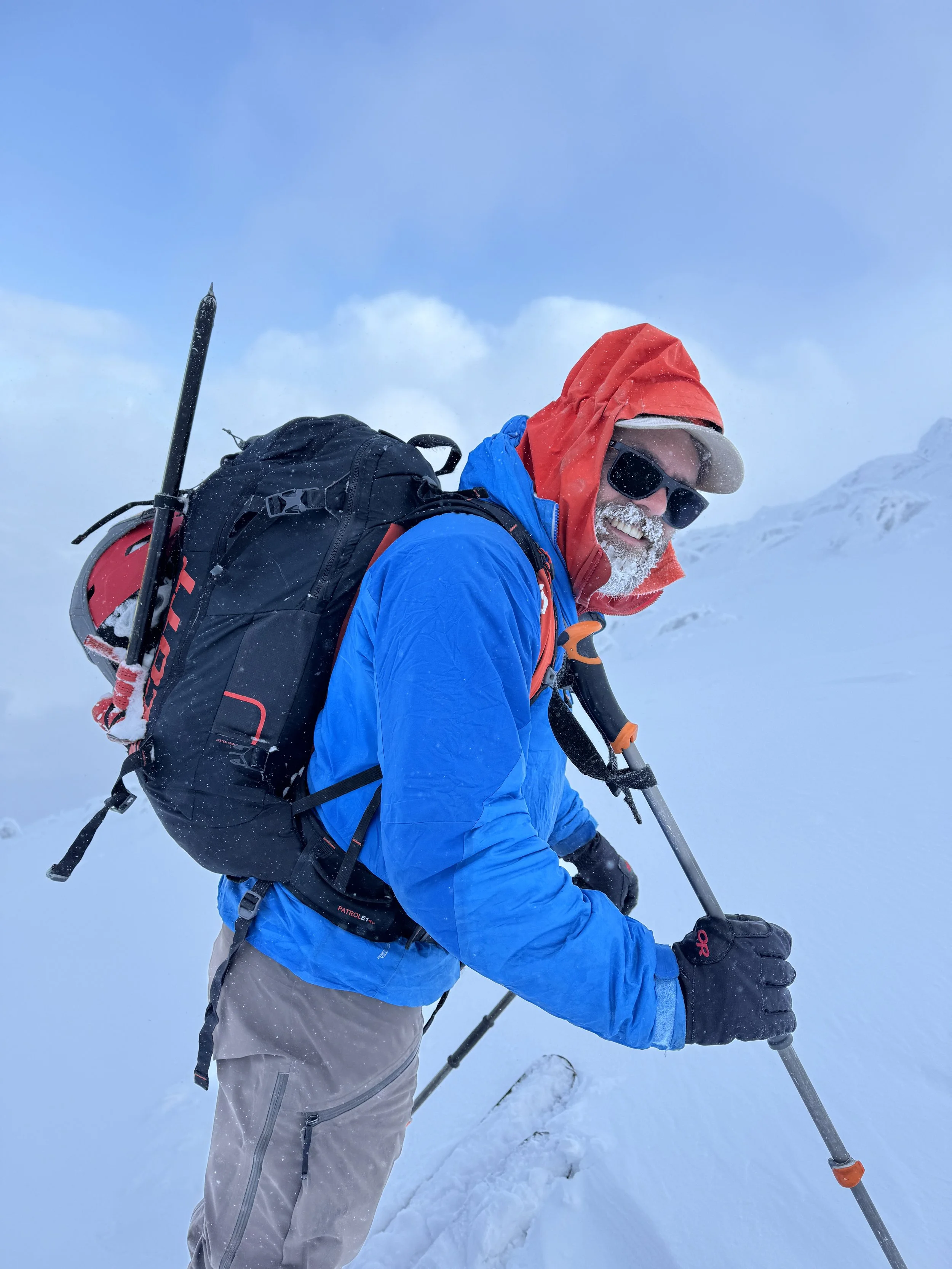 A devilishly handsome ski guide leans on his pole