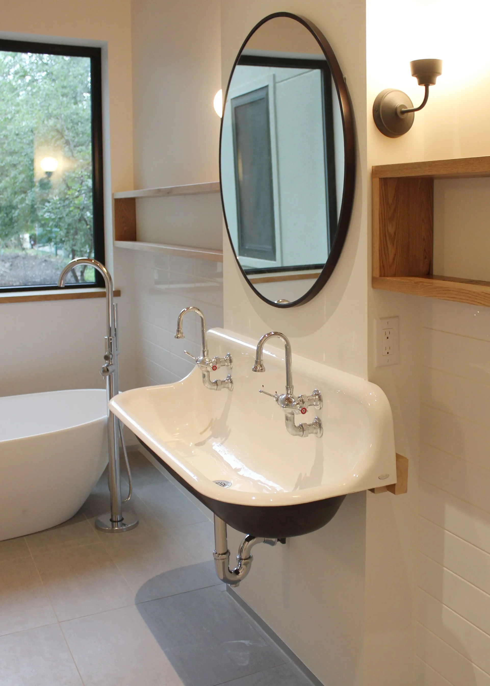 Bathroom featuring old fashioned trough sink, custom wood shelves (milled from trees taken down on site) and organic shaped hand-cast bathtub