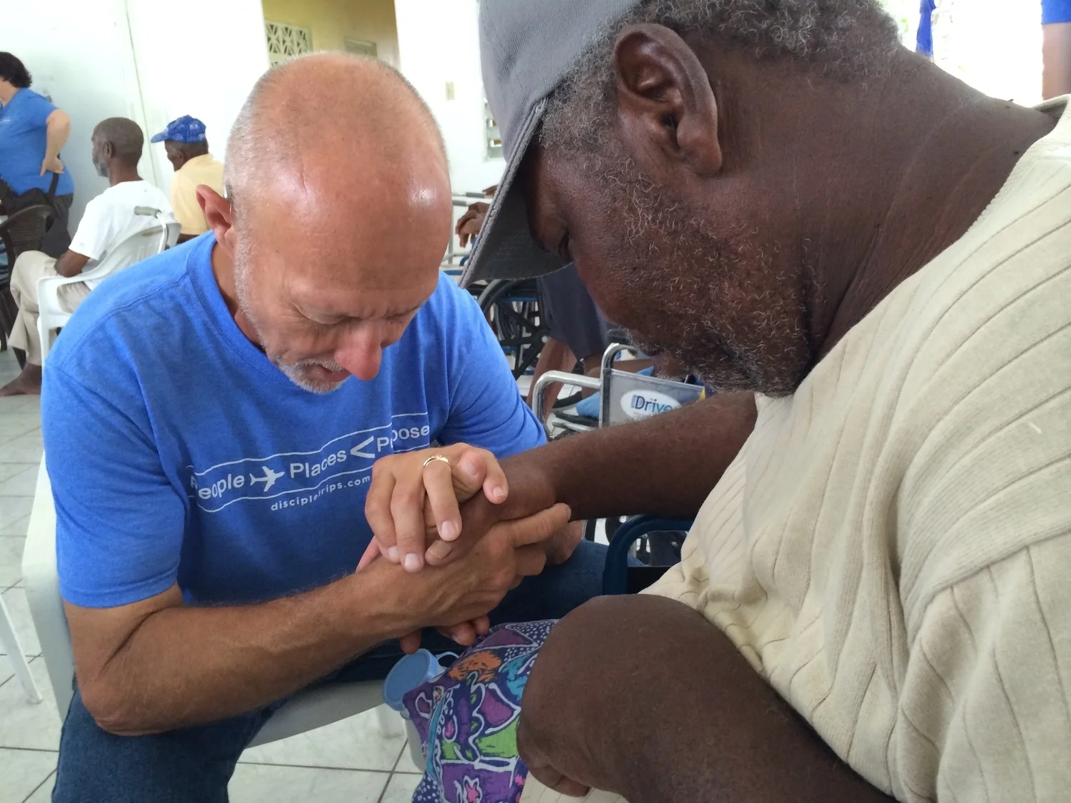 Bob praying with a resident of the Fienne's Institute in Antigua.