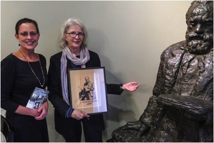 Golden Alley Press Editor Nancy Sayre and DAHA Board Member Majda Kallab Whitaker display book The House of Prague and etching of Dvořák next to statue by Ivan Mestrovic in Dvořák Room. Photo courtesy of Czech Center New York.