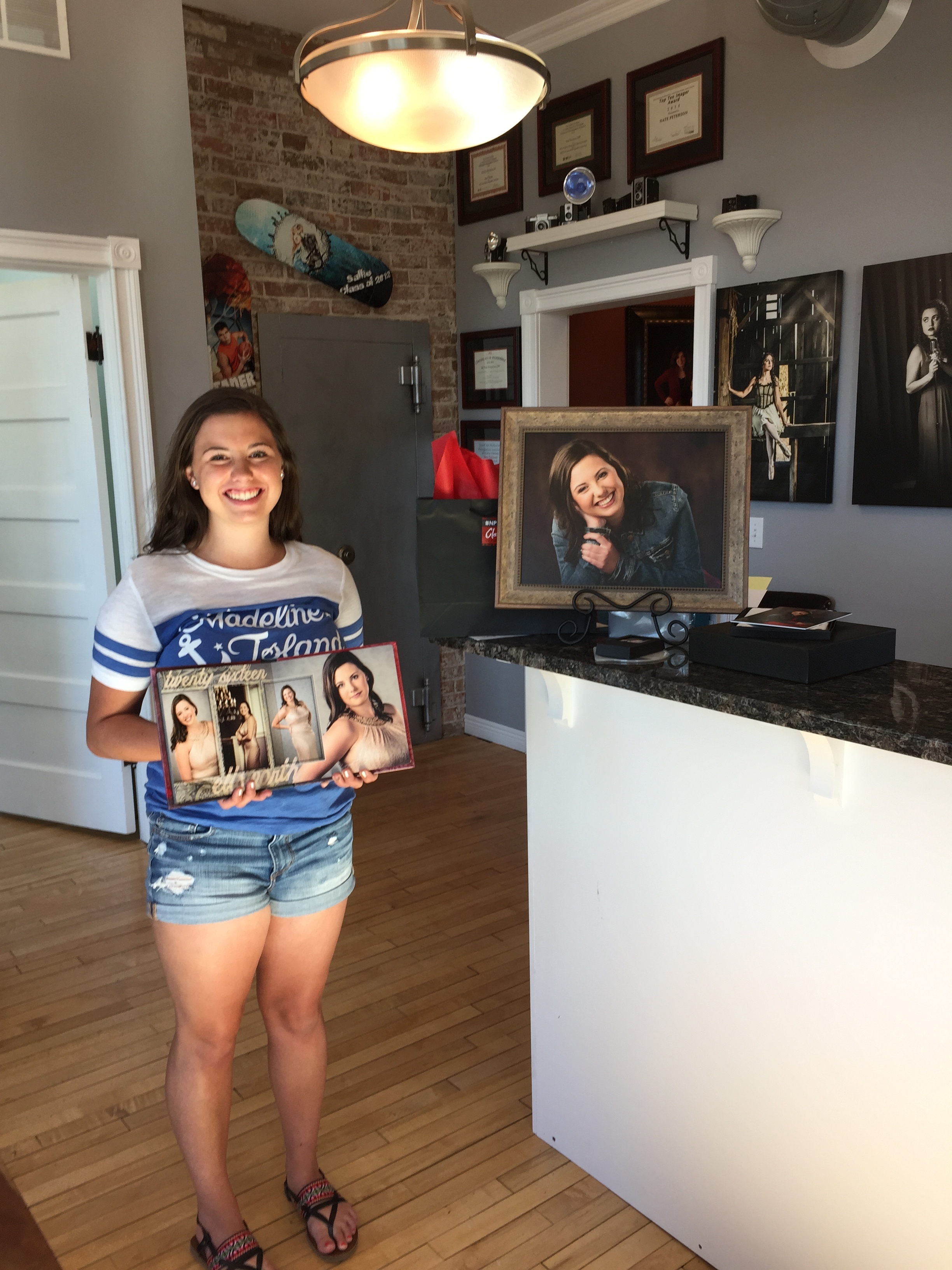 Ellsworth Senior, Madeline, posing with her favorite album spread, wall portrait and bag full of goodies.
