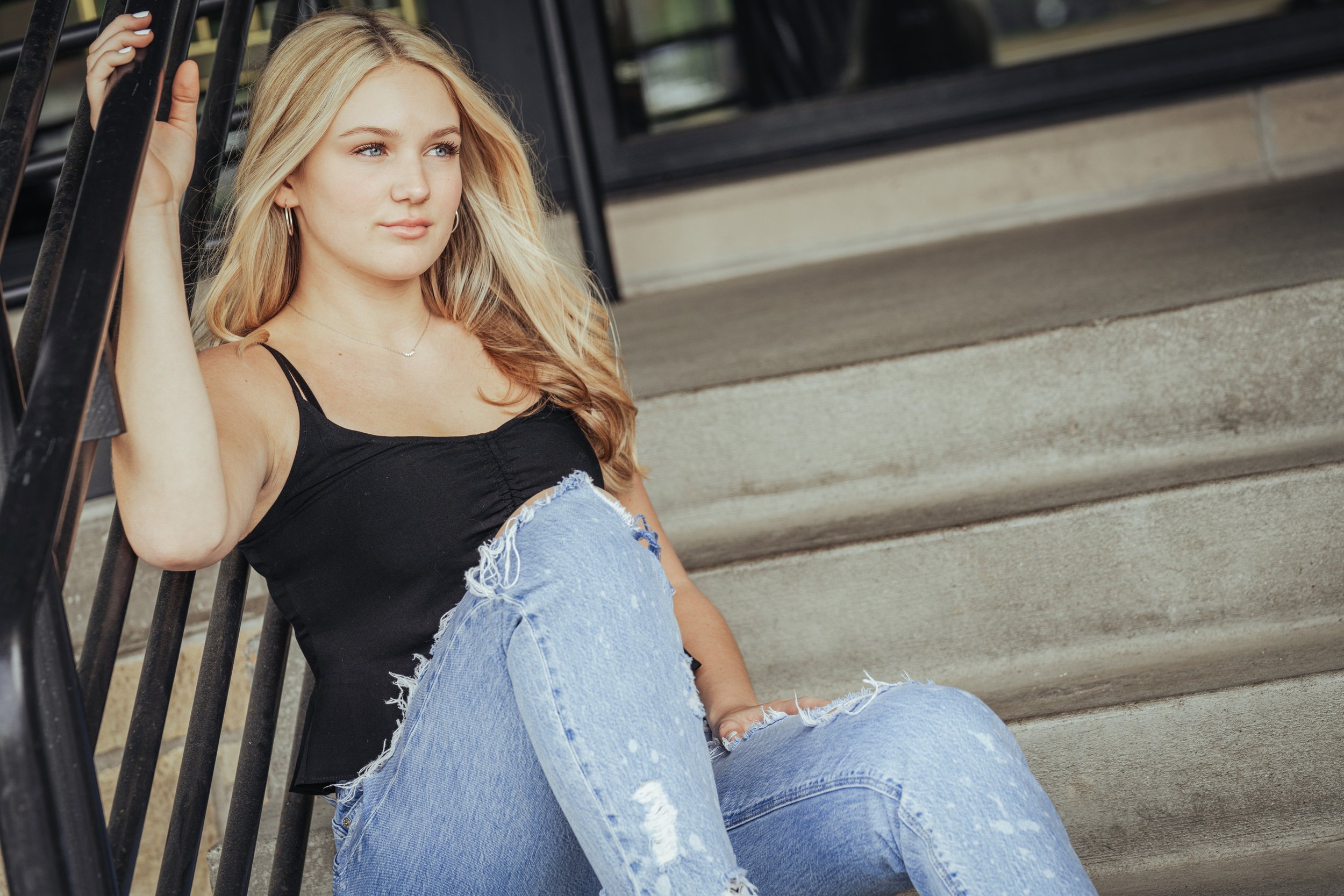 Urban sitting on steps with railing senior girl