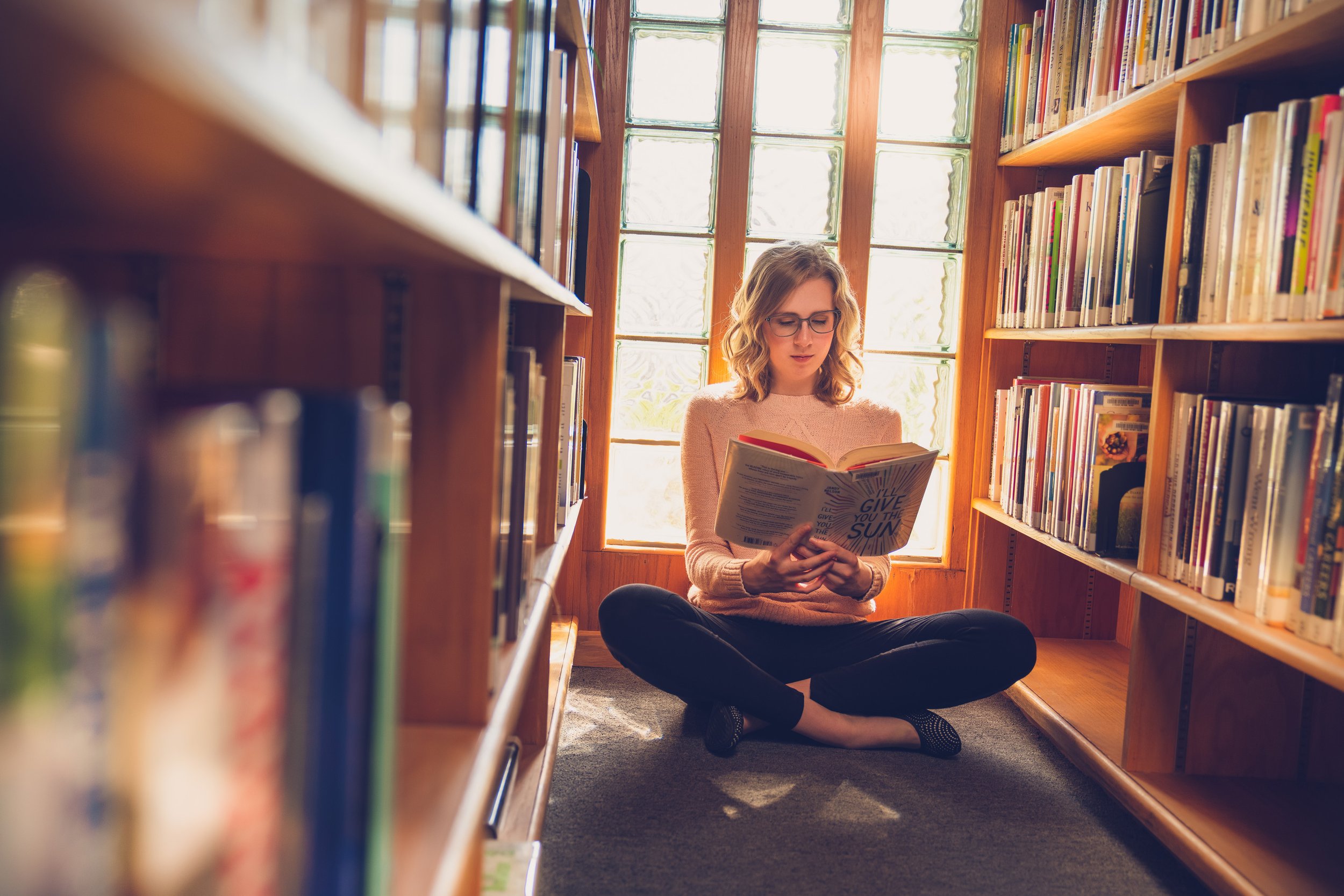 Senior girl reading in library 