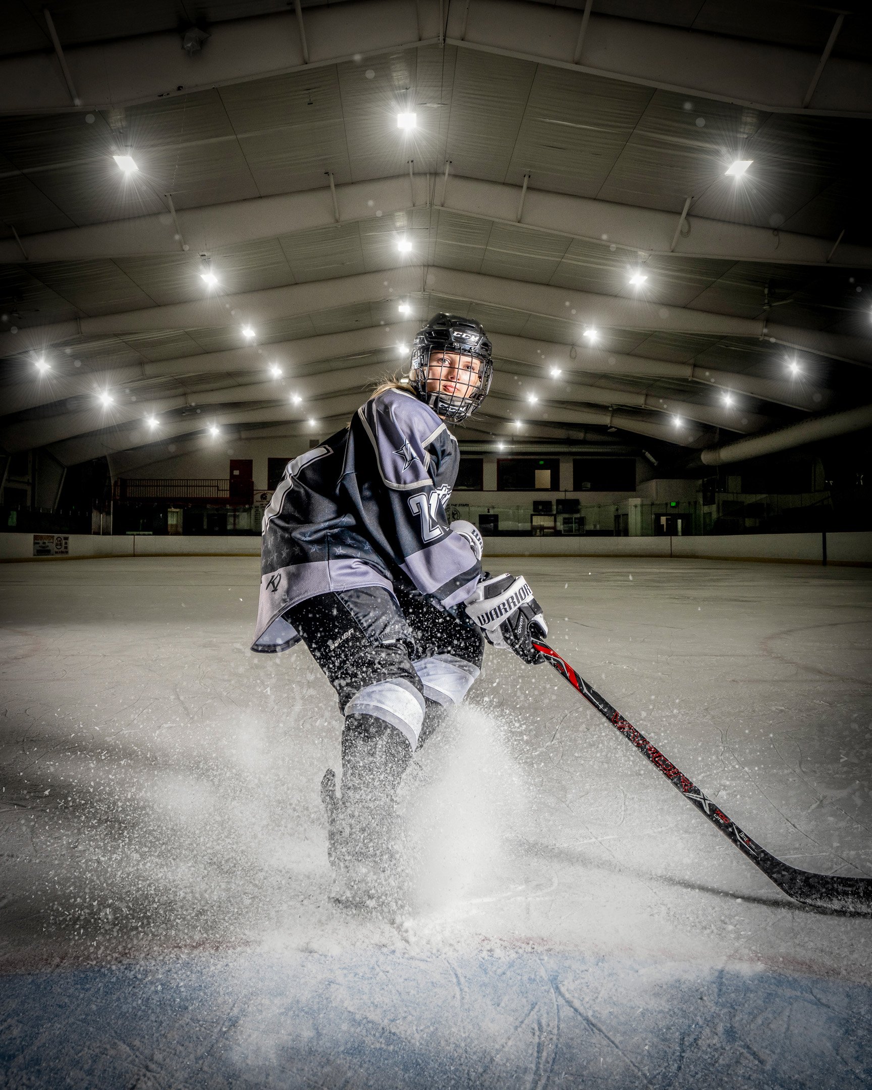 Girl hockey player blowing up snow from stopping quickly