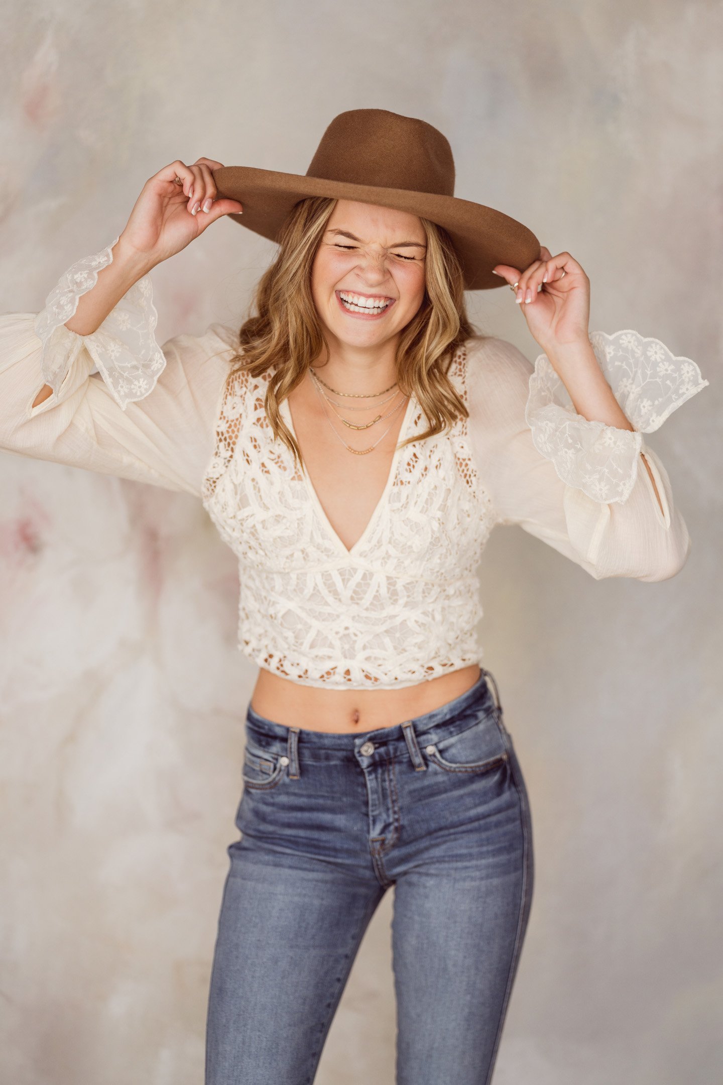 Laughing girl in white with brown fedora hat