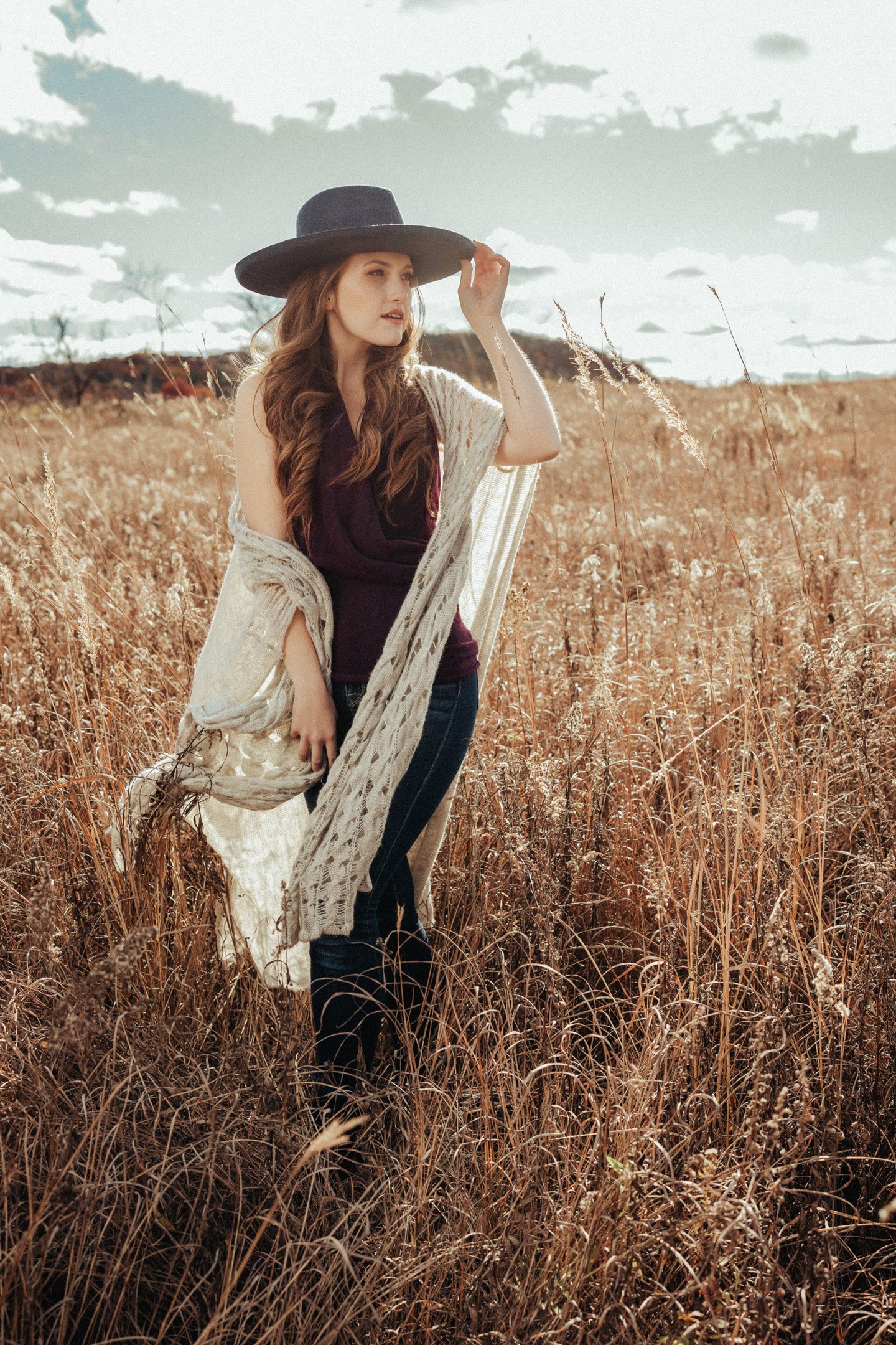 Girl in wheat field with black fedora and boho outfit