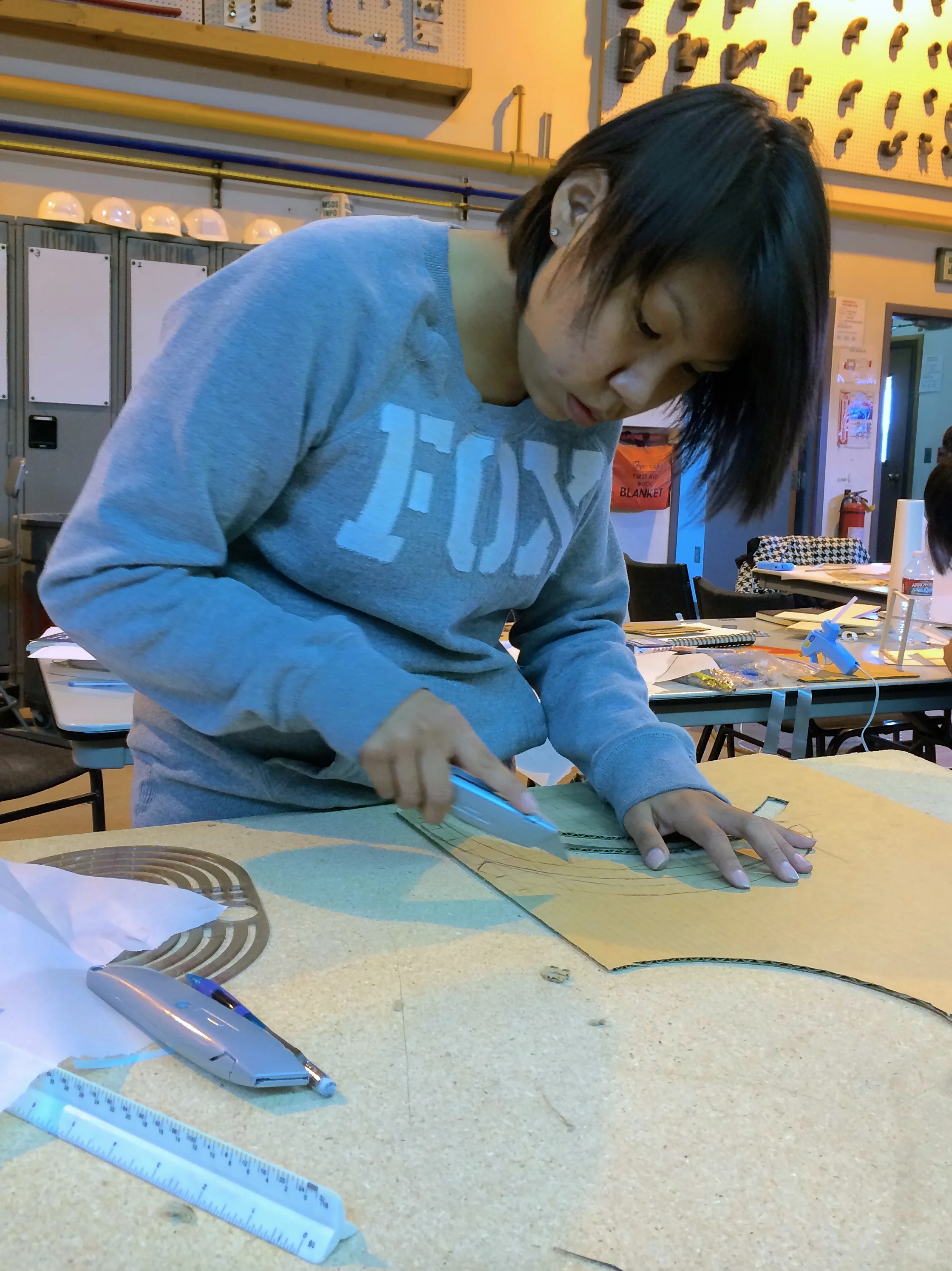 Marina cuts structural ribs from cardboard.