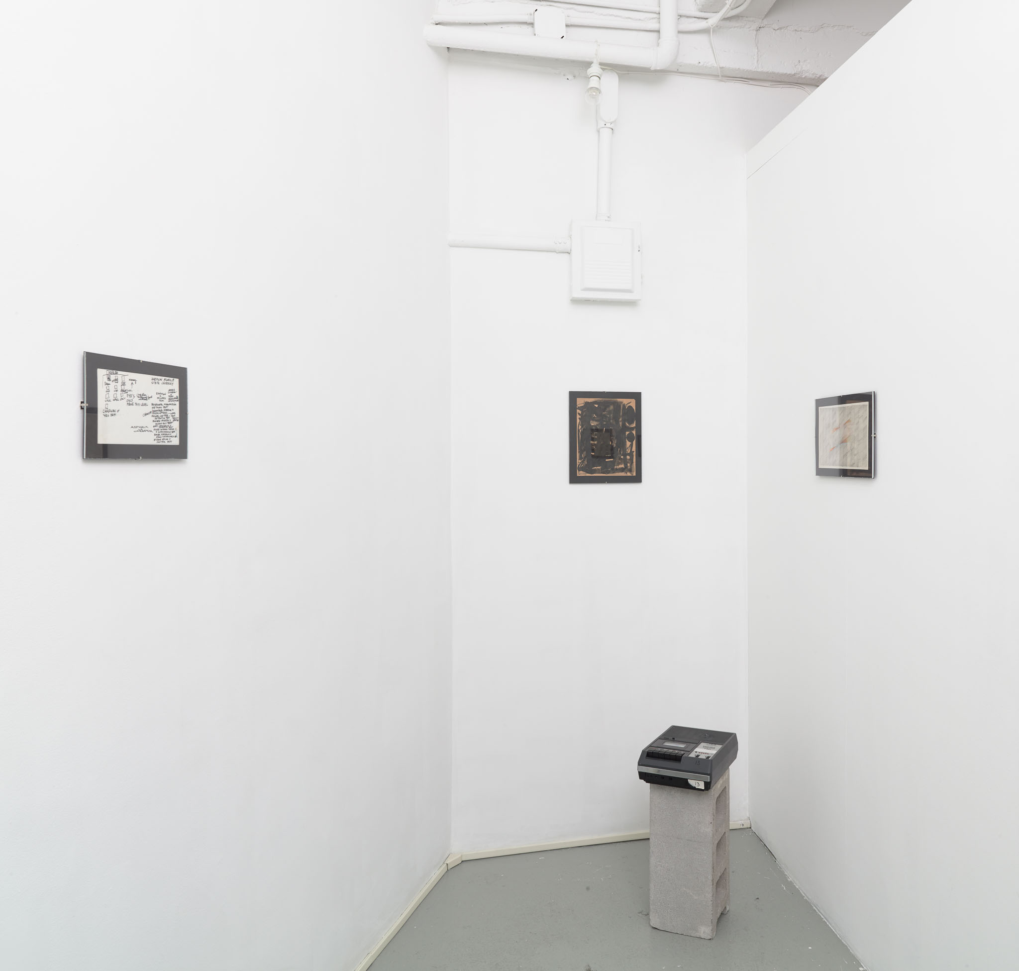 Installation view of Malcolm McClain: Visual Textual, showing framed works by McClain and casette players