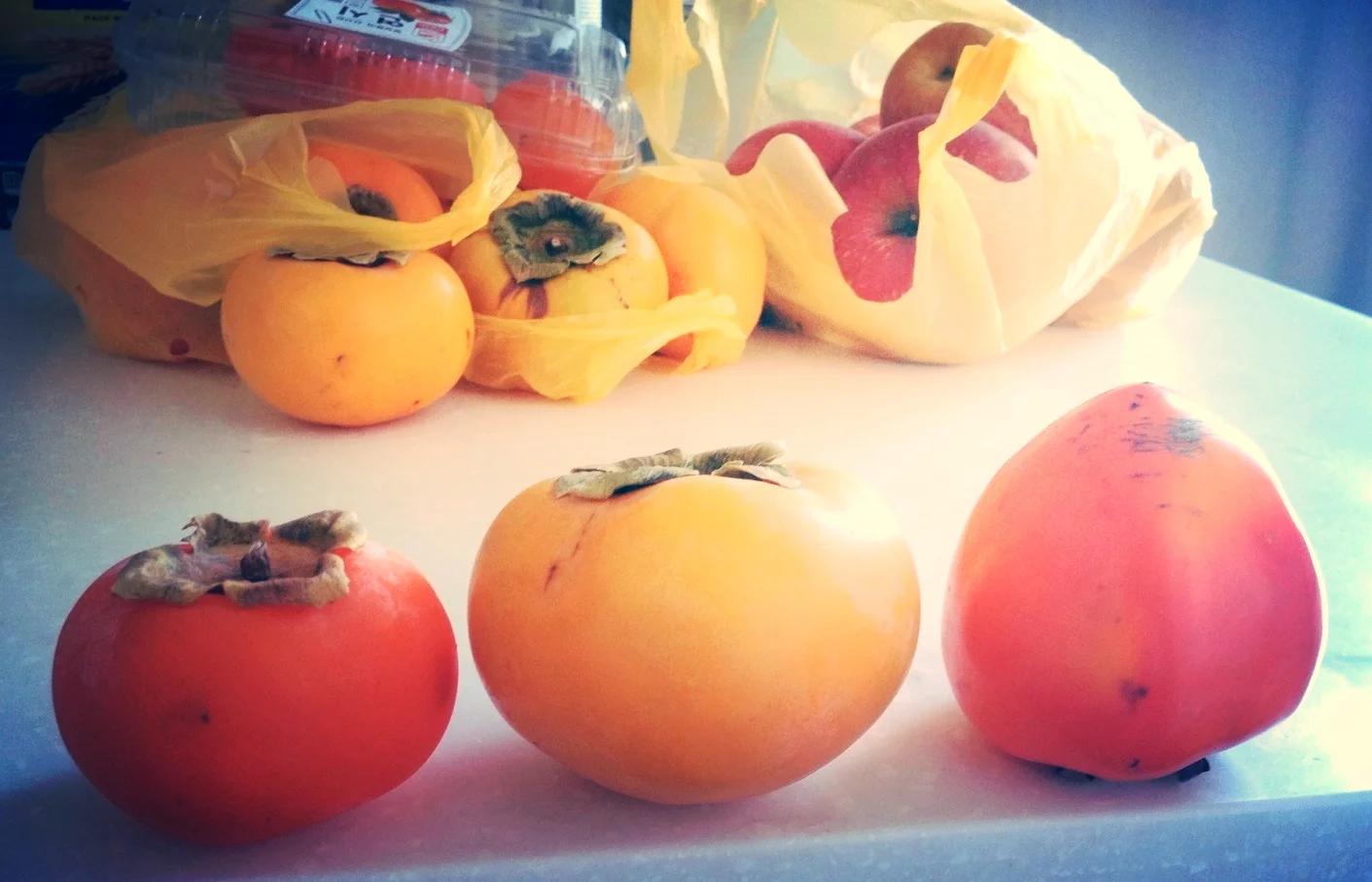 There are 3 main different kinds of persimmons. From left-right: 연시 (yun-shi), 단감 (dan-gam), 홍시 (hong-shi). 1 and 3 can be made into 곷감 (ggot-gam) which is simply a dried version of the fruit. These are delicious and chewy when dried, and can also be cut up and used as fillings for Korean cookies. 1 and 3 can also both be put in the freezer and enjoy as a frozen fruit treat. Once it thaws a bit, the frozen flesh tastes like a sweet sorbet - it's an all natural healthy option to ice-cream! 