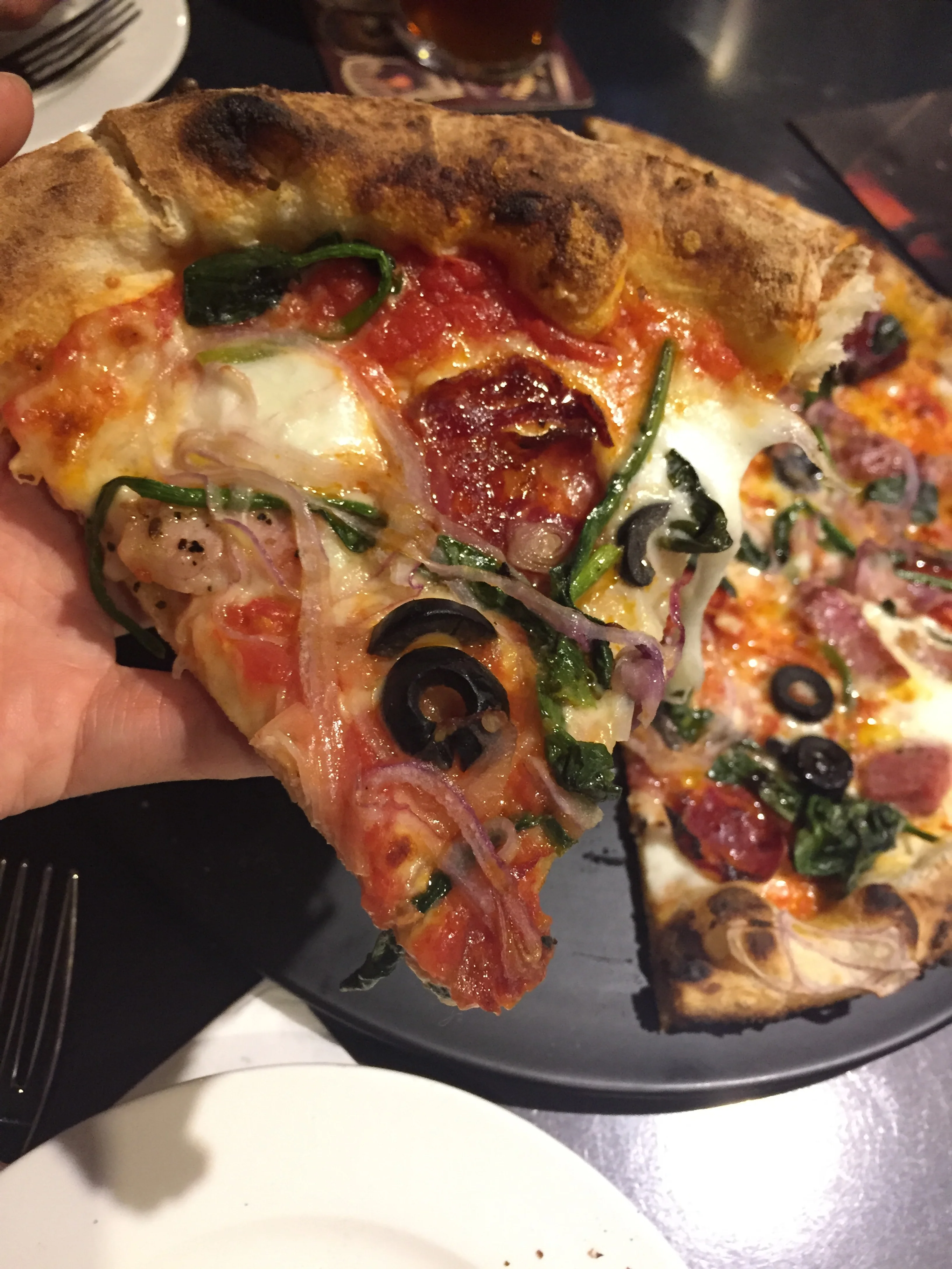 Neapolitan pizza is characterized as having more sauce than cheese, therefore leaving the middle of the pie typically wet or soggy, which is why the sizes are generally smaller, more like a personal pizza size. They are cooked at very high temperatures for more than a minute and a half to get a perfect crispy yet chewy crust with the cheese just bubbling.