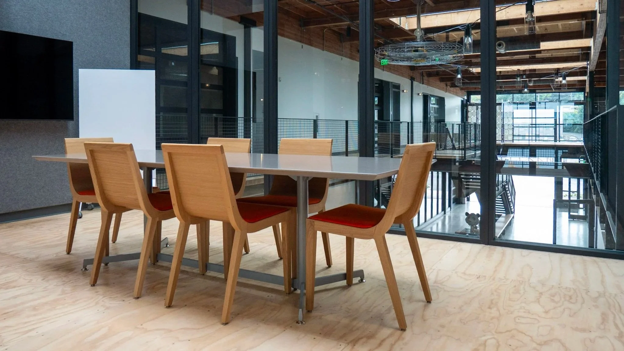 A modern 6 person conference room with glass walls and a mobile whiteboard