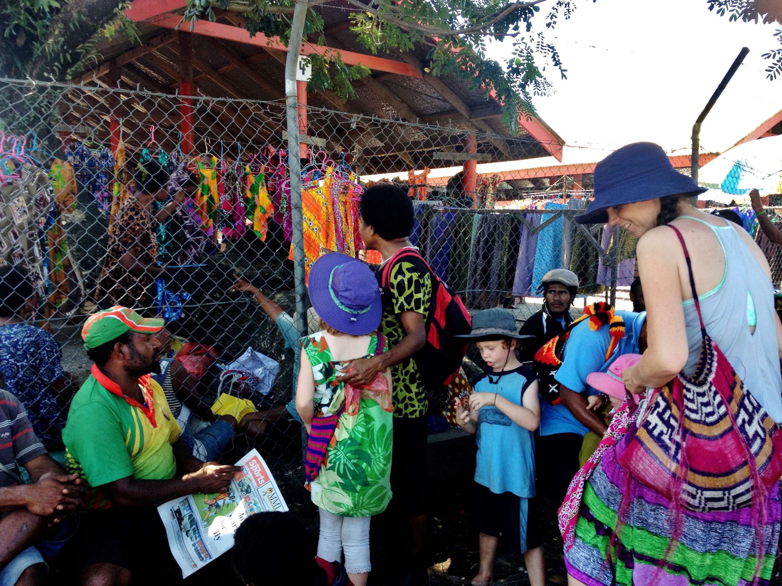 The fence didn't stop Auntie Belinda from buying the girls a meri blaus at the Main Market in Lae while we waited outside for a PMV.