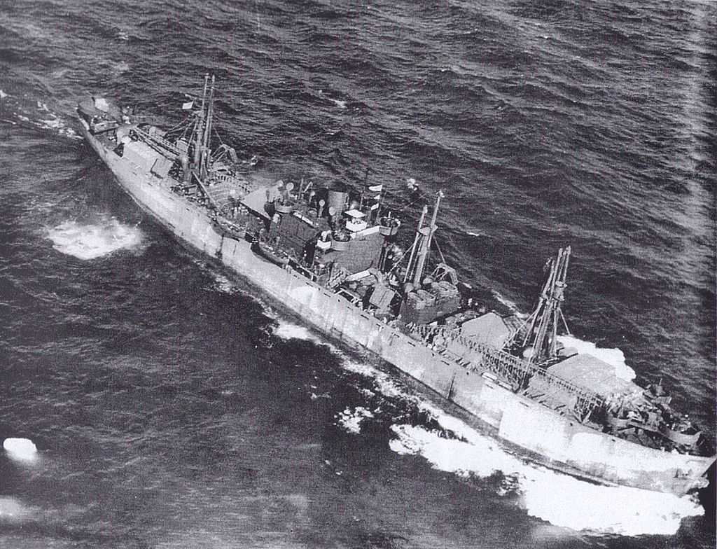 This aerial photograph of the JOHN W BROWN outbound from the US carried a large deck cargo even after her conversion to a "Limited Capacity Troopship." This shot is most likely taken in the summer of 1943 during her second voyage. Notice how low in the water she is.
