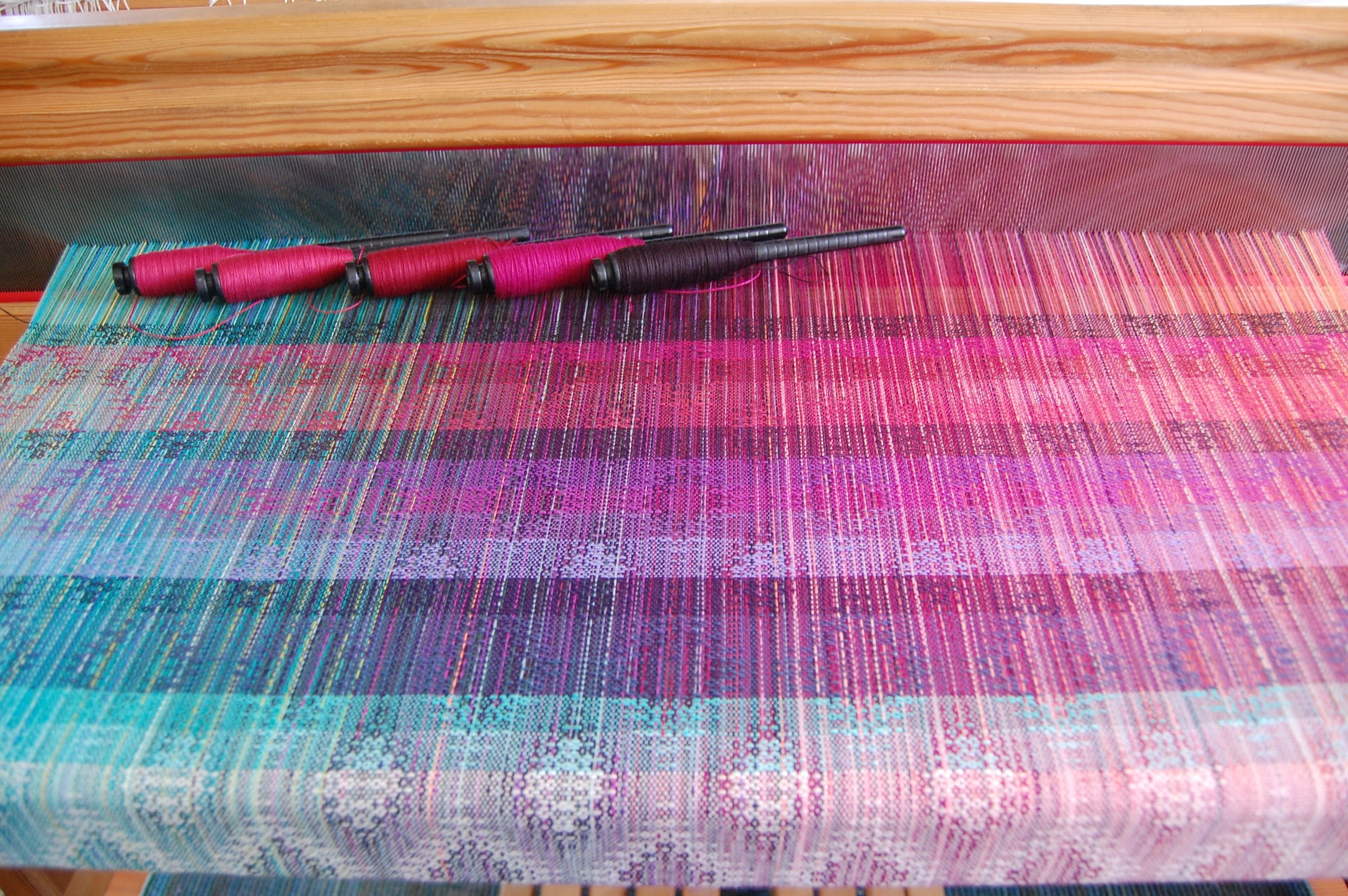 "Reds" + black cotton weft choices (top 5 stripes) . The bottom stripe corresponds with the left-most pern: raspberry Egyptian cotton, burgundy mercerized cotton, burgundy Egyptian cotton, raspberry organic cotton, black Egyptian cotton