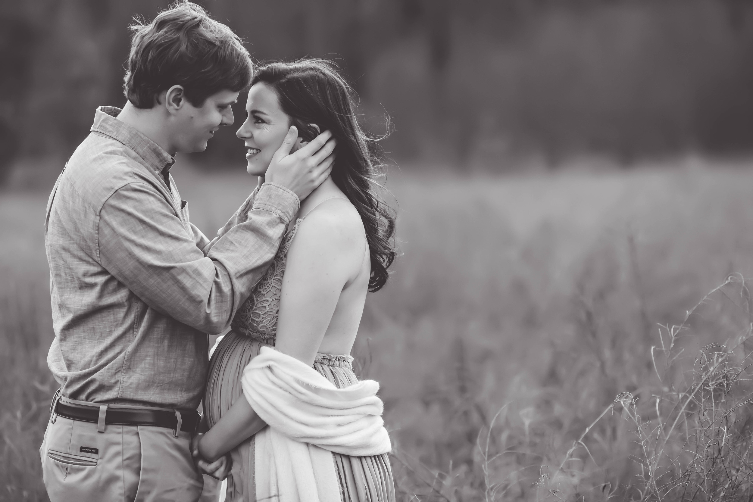 Couple embracing in a field outside of Atlanta GA during maternity photo shoot