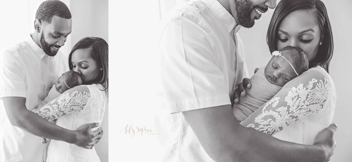  Side by side, black and white image of an African American mother holding her newborn daughter and kissing her head, while her husband stands beside her smiling down at their daughter with his arms around his wife.&nbsp; 