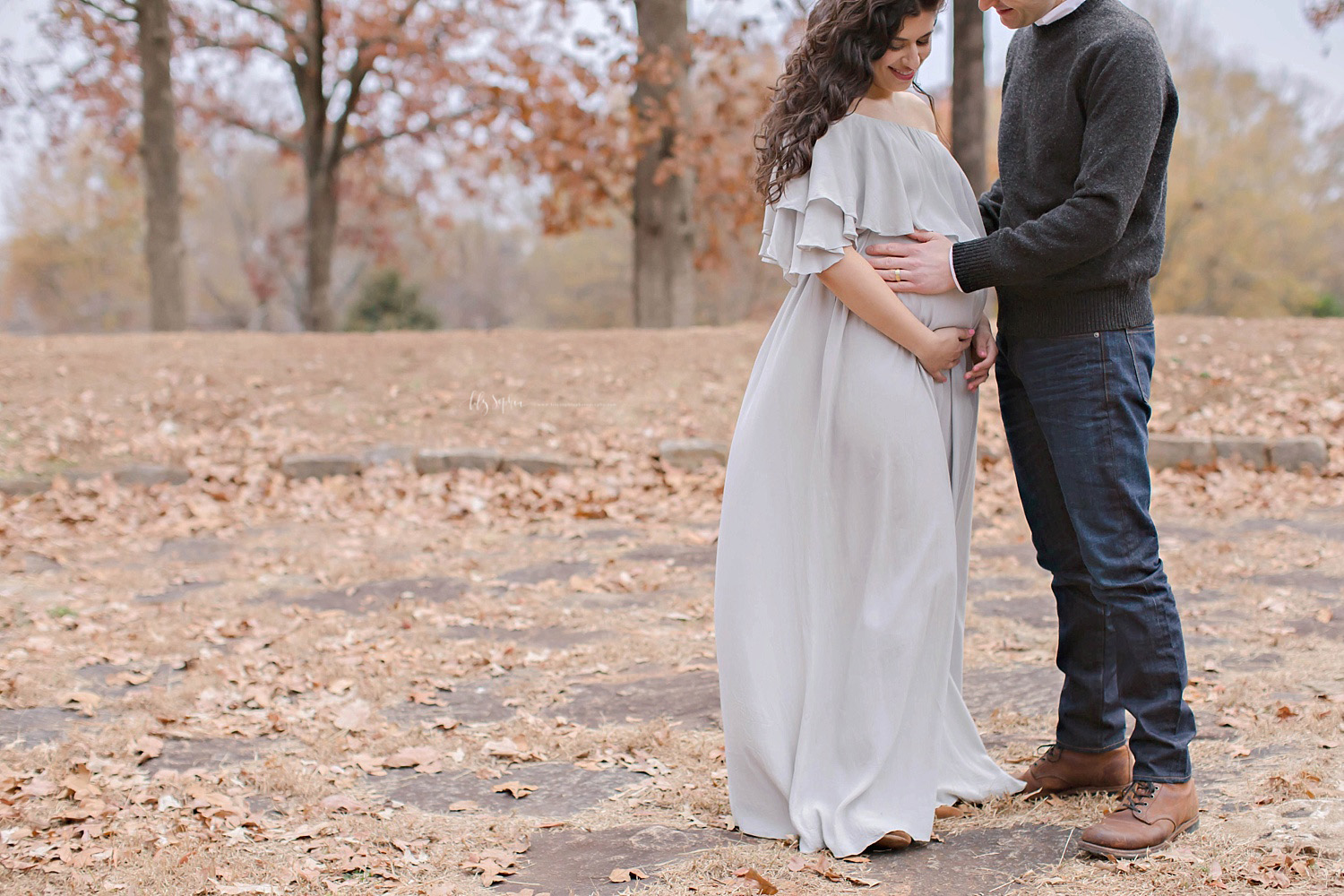 Beautiful maternity image with dress blowing in the wind taken by Lily Sophia Photography on a winter day in an Atlanta park