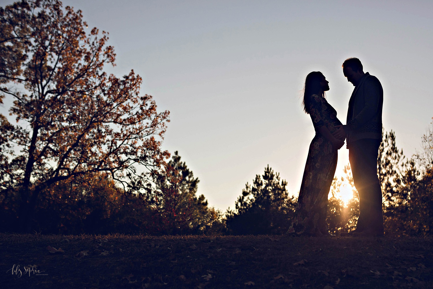  Silhouette image of pregnant woman facing her husband on a hill in Atlanta.&nbsp; 