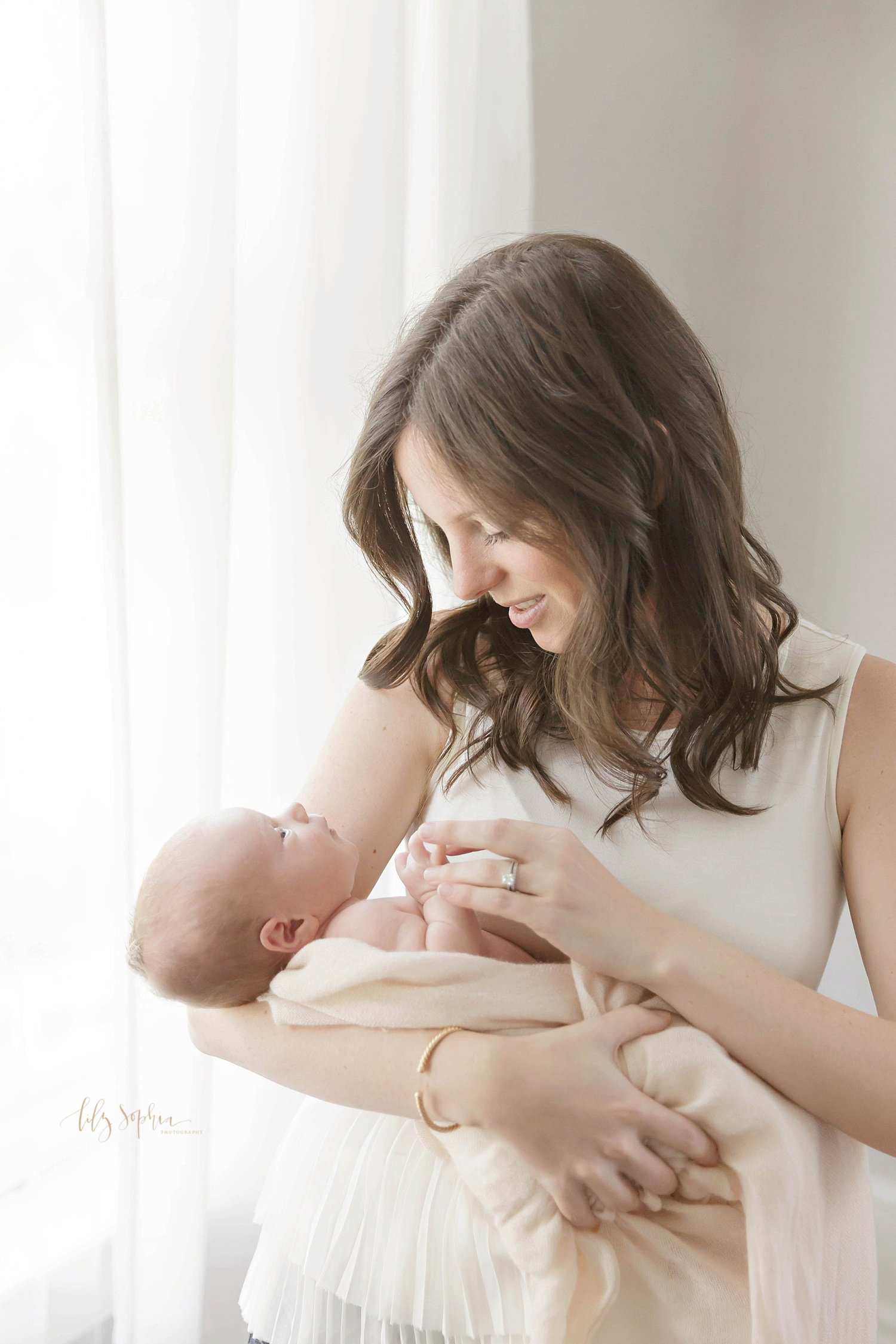 Portrait of new Atlanta mother holding and admiring newborn baby girl 