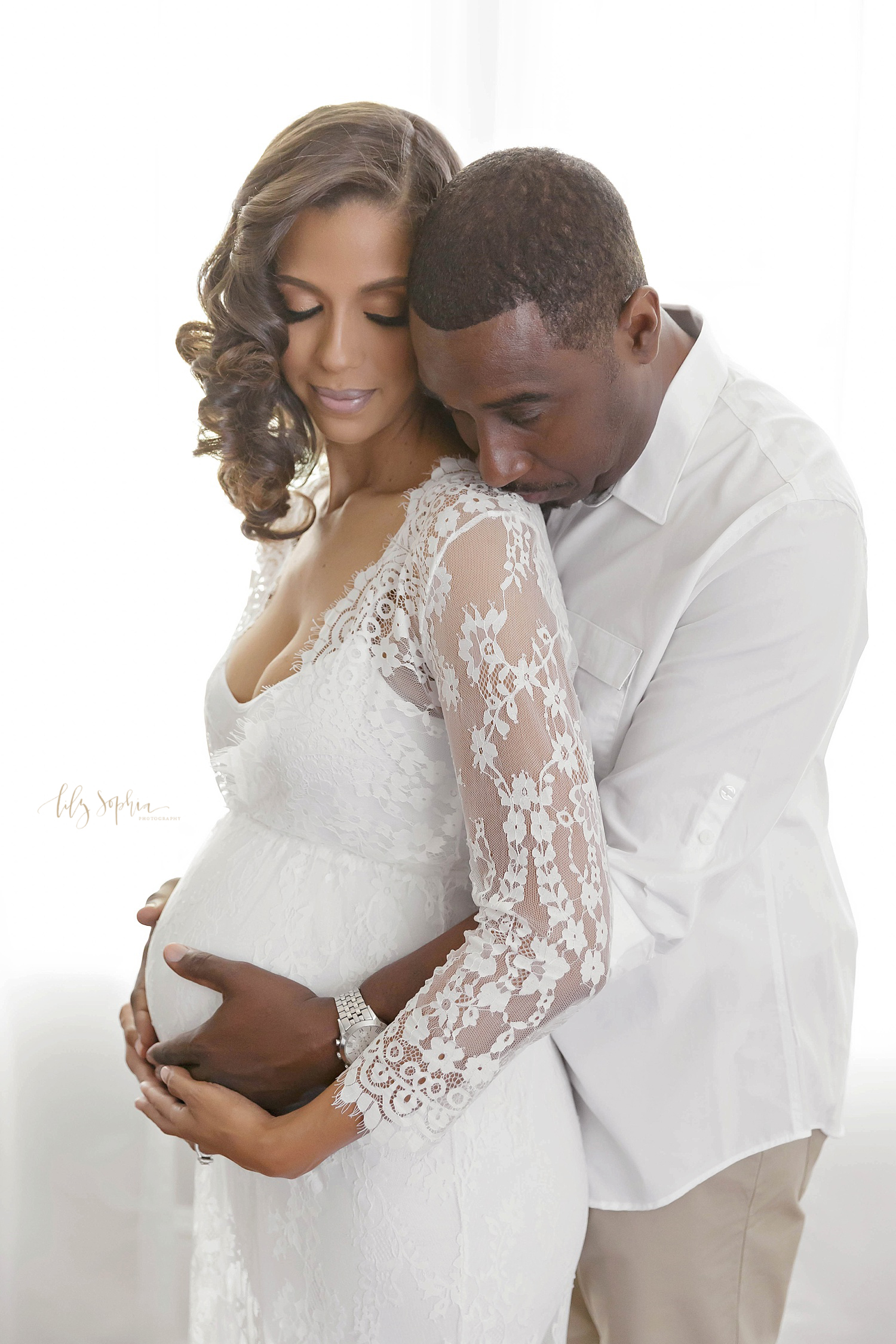 African American couple cradling pregnant belly in Atlanta natural light studio 