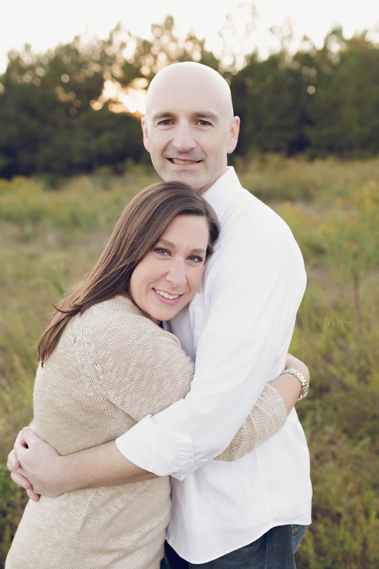  A couples photo of a mom and dad hugging and looking at the camera during a family portrait session in Atlanta. 