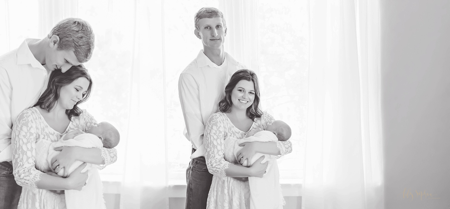  Side by side, black and white images of a new family of three. In the first image the father is standing behind the mom with his arms around her, while they both smile down at the baby in her arms. In the second image the father is standing behind h