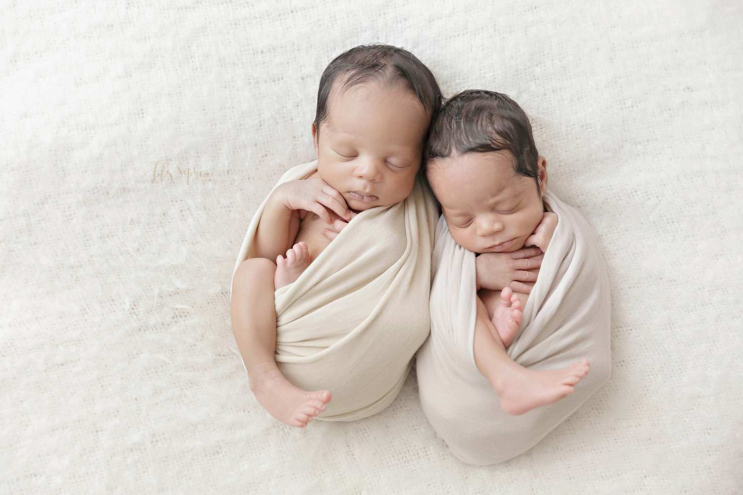  Image of sleeping, newborn boy/girl African American twins, wrapped up with their legs out, cuddled next to each other.&nbsp; 