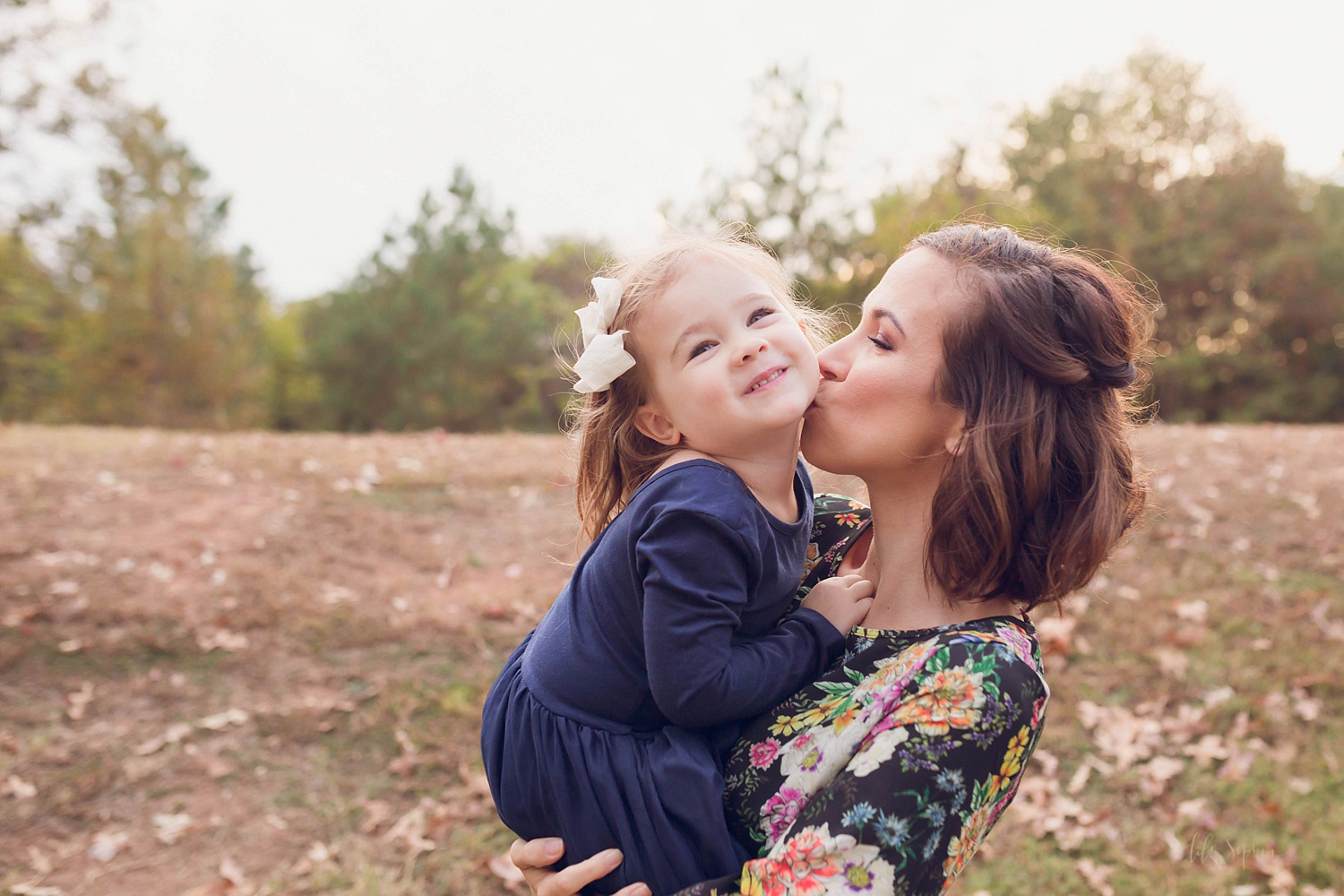  A mother kissing her daughter on the cheek.&nbsp; 