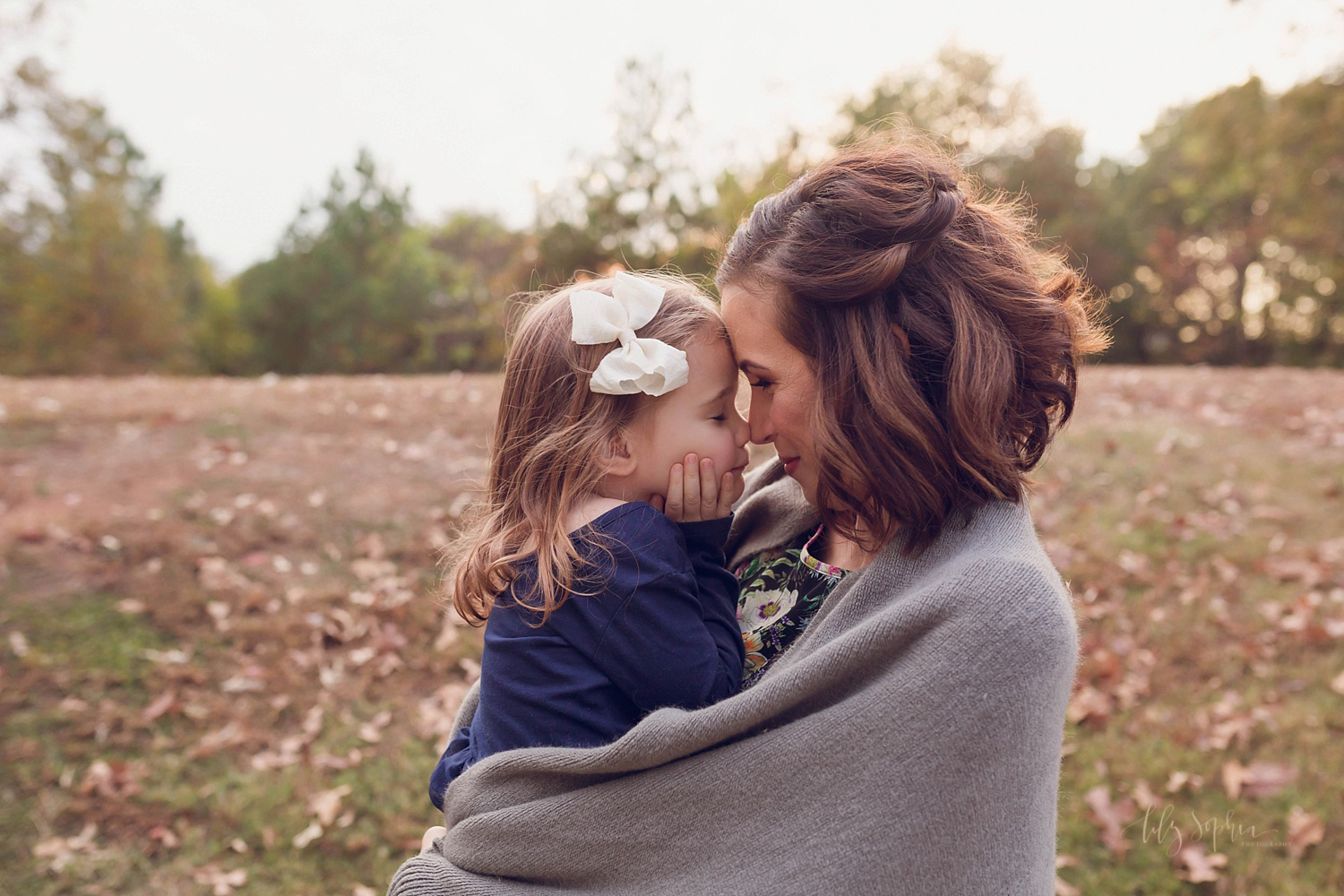  A little girl nuzzles noses with her mother while wrapped in a blanket at sunset in Atlanta.&nbsp; 