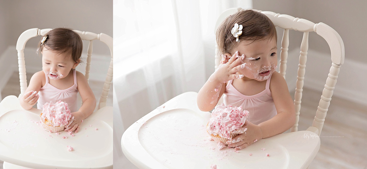  Side by side images of an Asian, baby, girl, sitting in an antique, wooden high chair. In the first image, she is looking at the icing on her fingers, in the second image she is smearing the icing on her face. 
