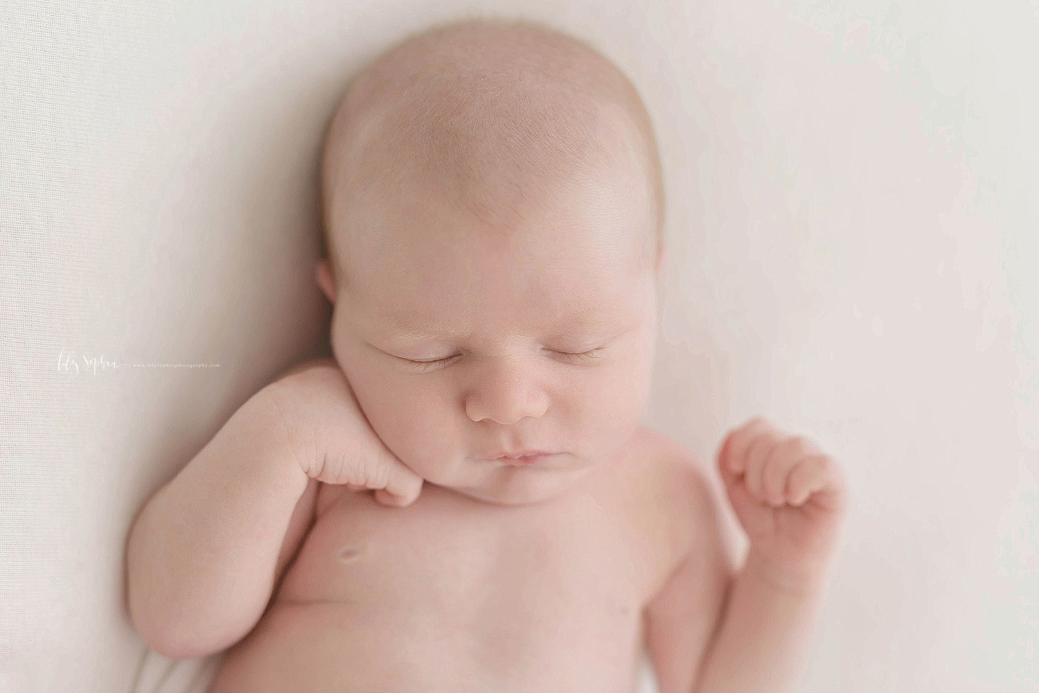  Image of a sleeping, newborn, boy, with one hand under his chin and the other by his shoulder.&nbsp; 