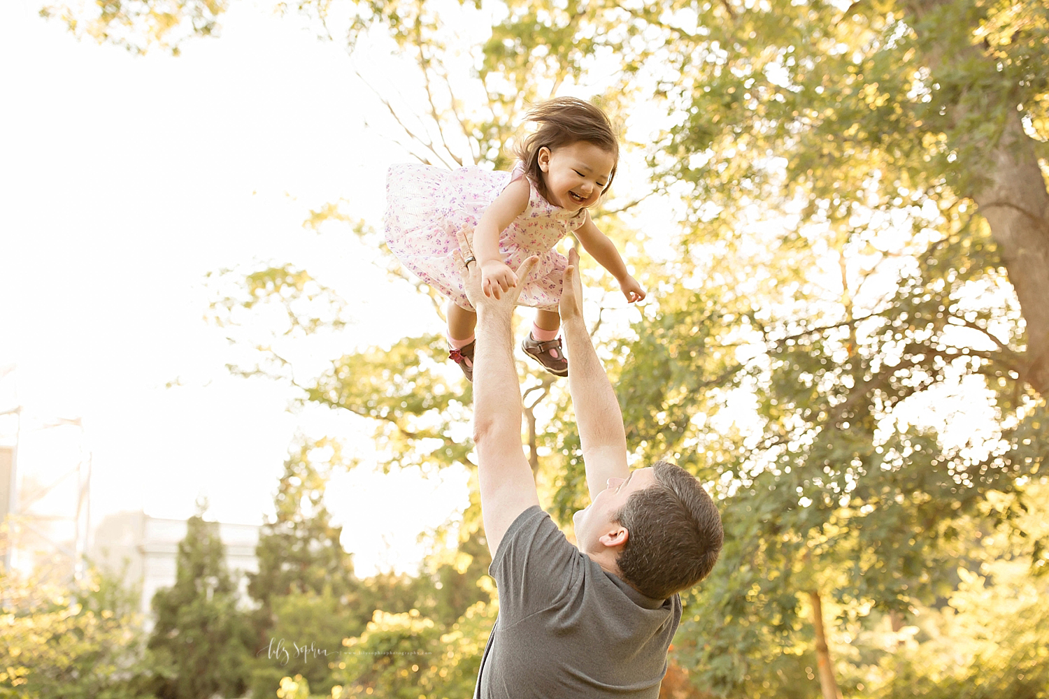  Image of a father throwing his half Asian daughter up in the air, and her laughing,&nbsp; 