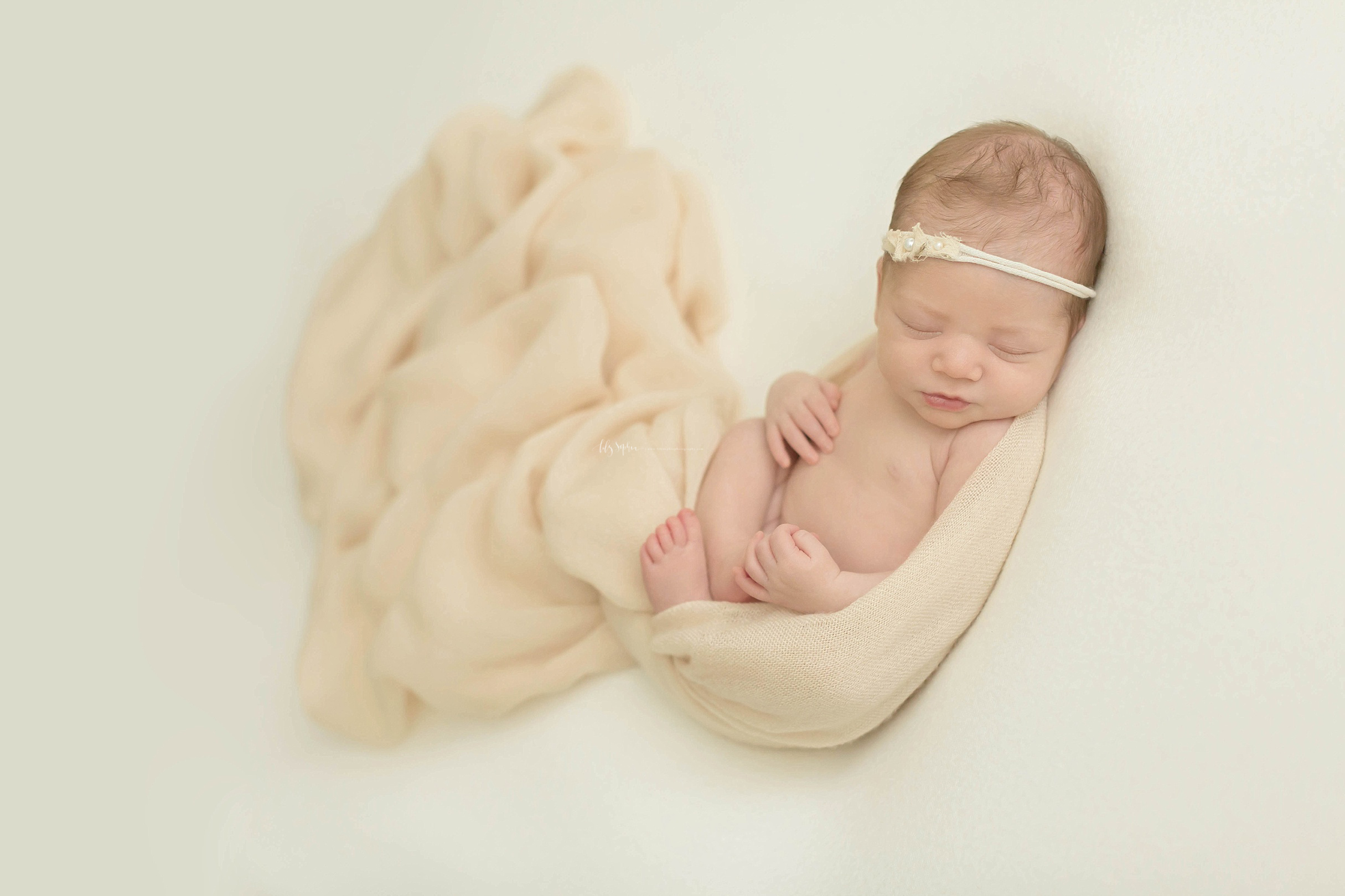  Image of a sleeping, newborn, baby, girl, wrapped in the egg pose.&nbsp; 